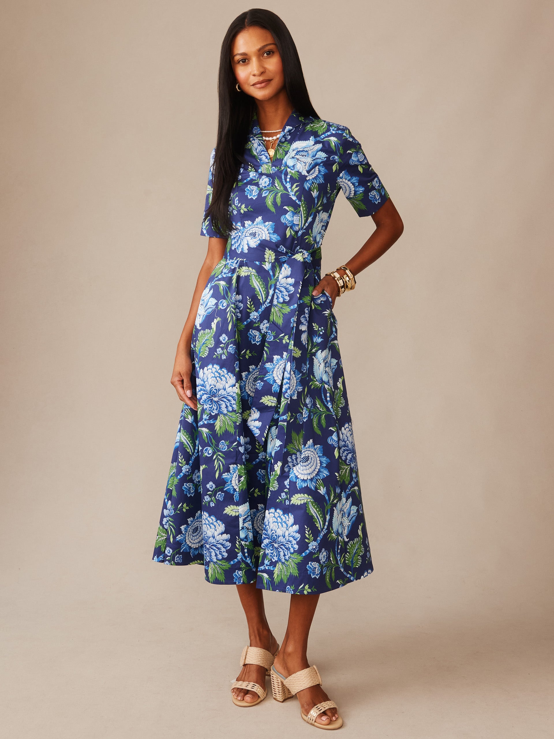 Woman wearing the Lily Dress in Cerulean Garden by J.McLaughlin, showcasing an effortlessly stylish floral dress in blue and green tones, reflecting enduring designs and innovative fabrics. A destination for defining style. Life, Well-Lived.