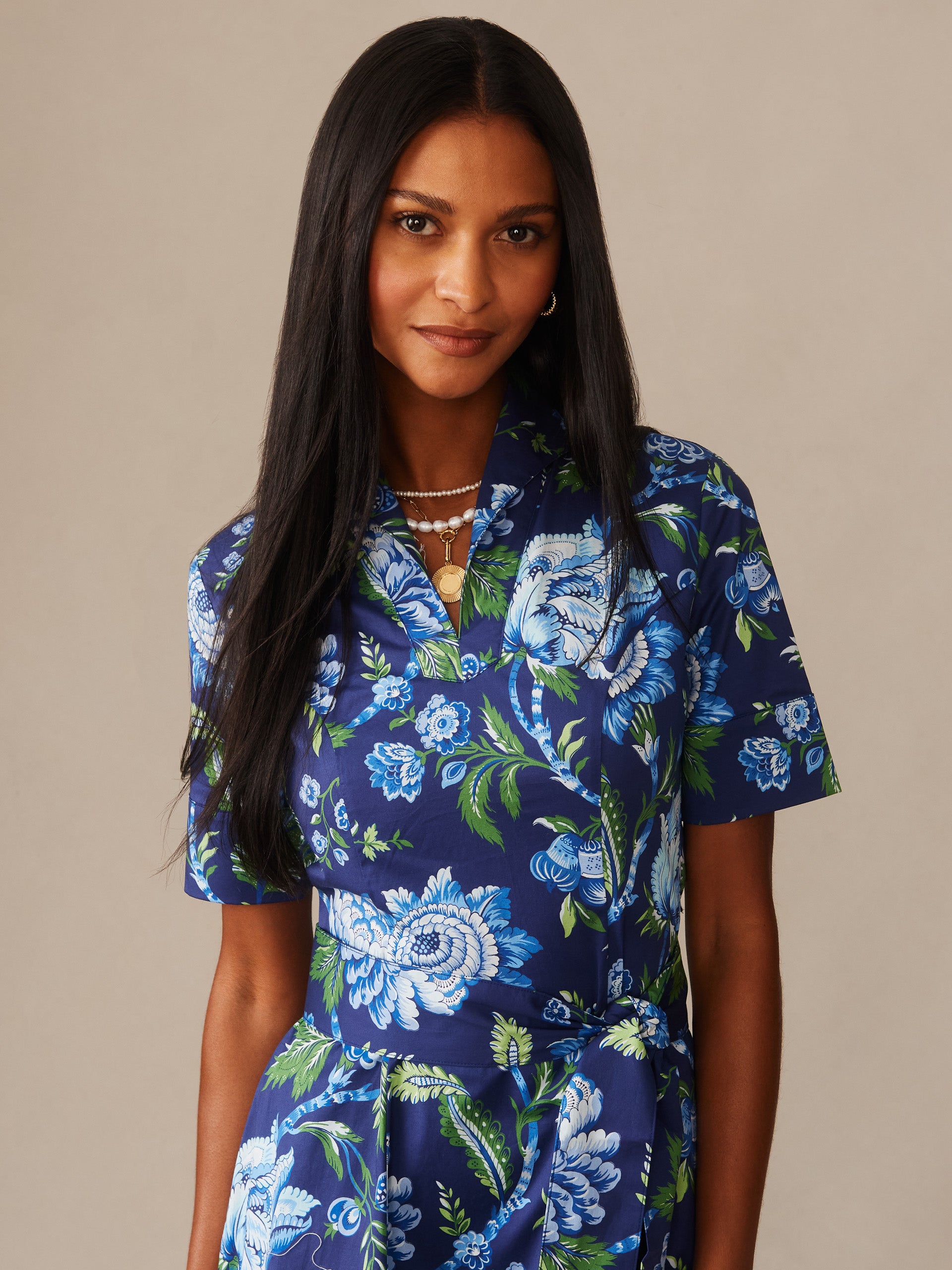 Woman wearing the Lily Dress in Cerulean Garden by J.McLaughlin, featuring a vibrant blue floral pattern with green accents, reflecting effortlessly stylish and enduring designs.