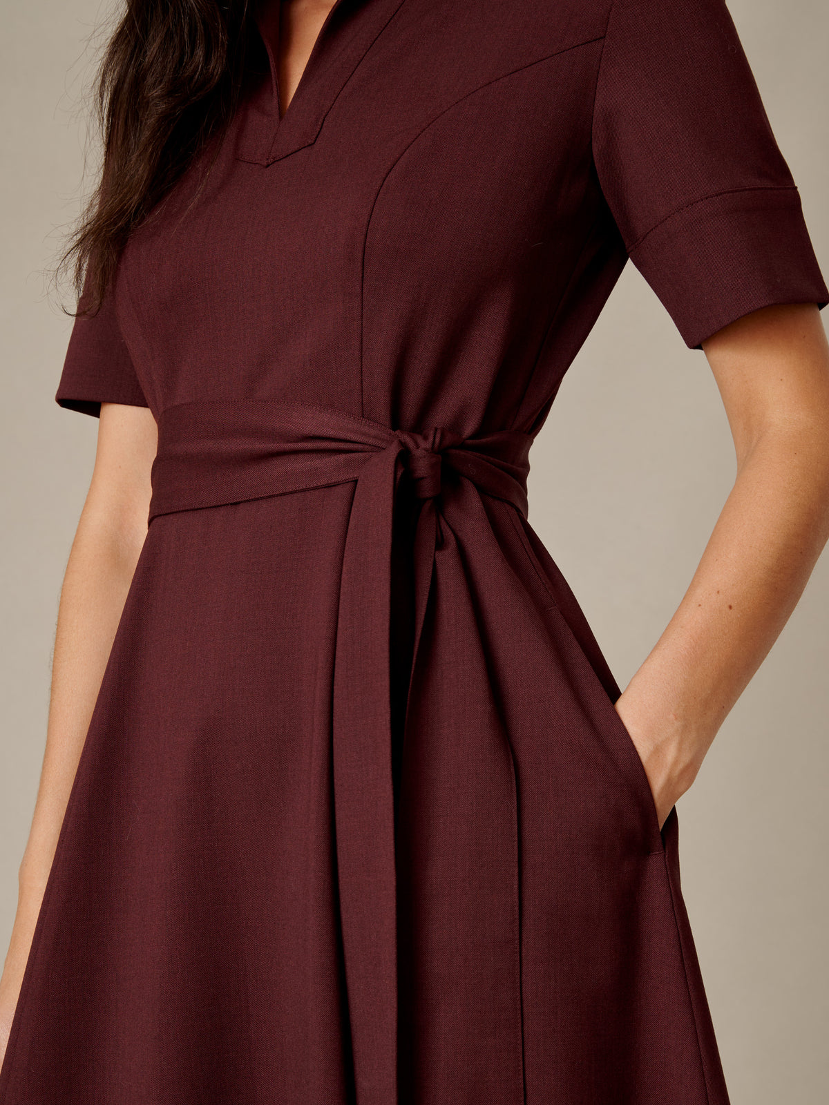 J.McLaughlin Lily Wool Twill Dress in burgundy with a collared V neckline short sleeves tie waist and practical pockets