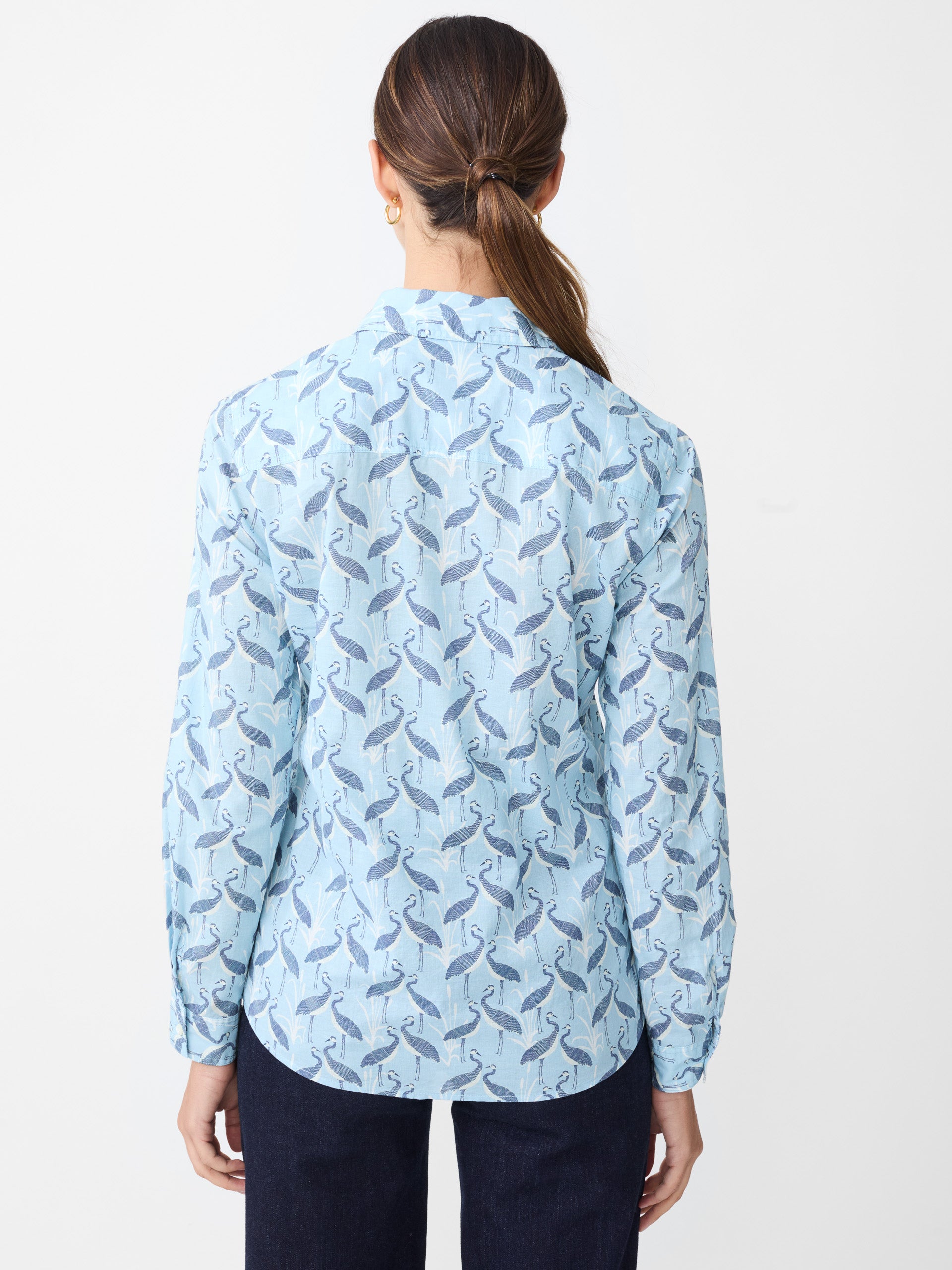 Model wearing J.McLaughlin Lois shirt in light blue/navy made with cotton.