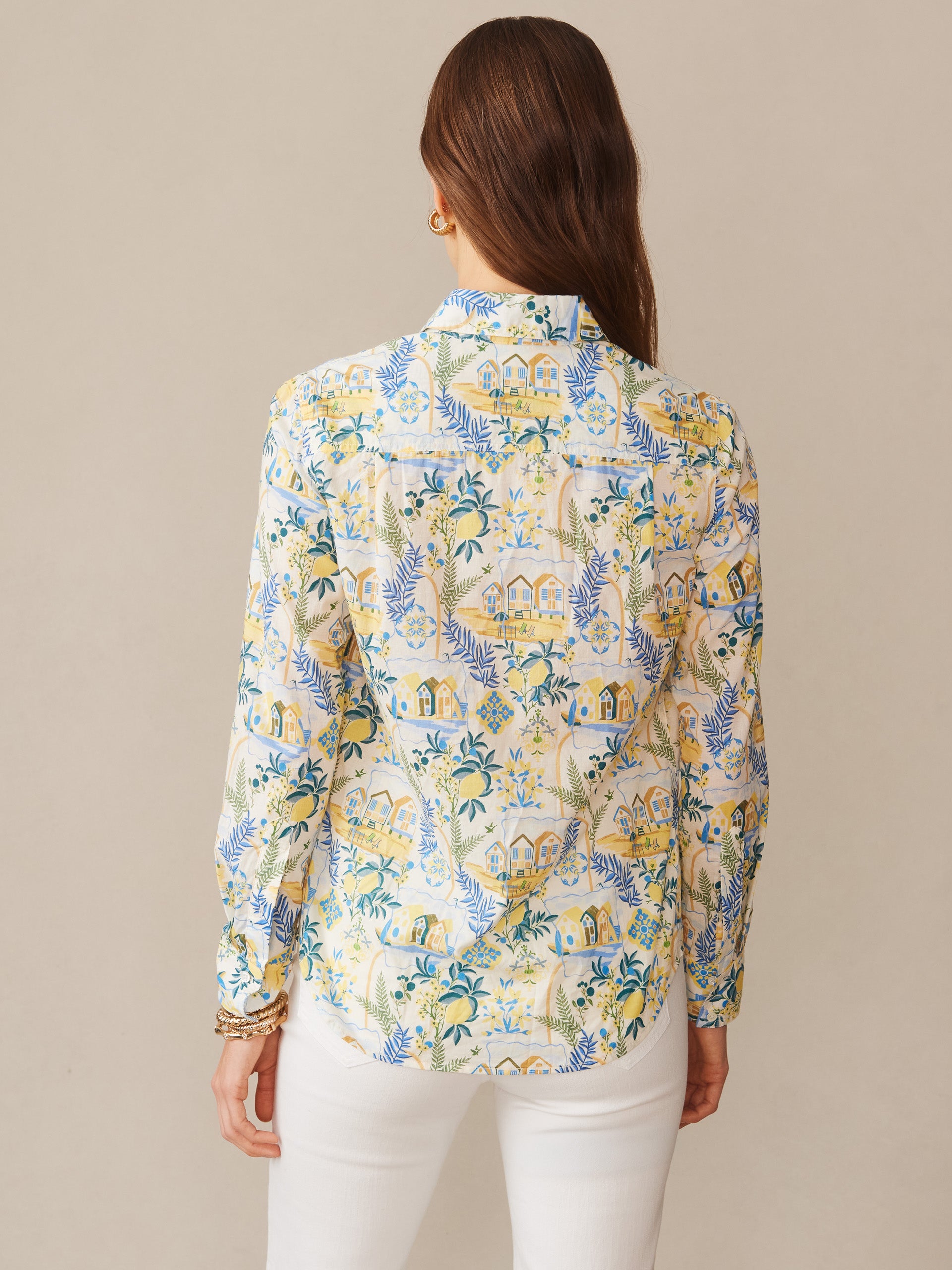 Woman wearing the Lois Shirt in Mini Amalfi Coast Stripe by J.McLaughlin, featuring intricate blue and yellow coastal illustrations on an off-white background, showcasing effortlessly stylish, enduring designs in a timeless blouse. A destination for defining style. Life, Well-Lived.