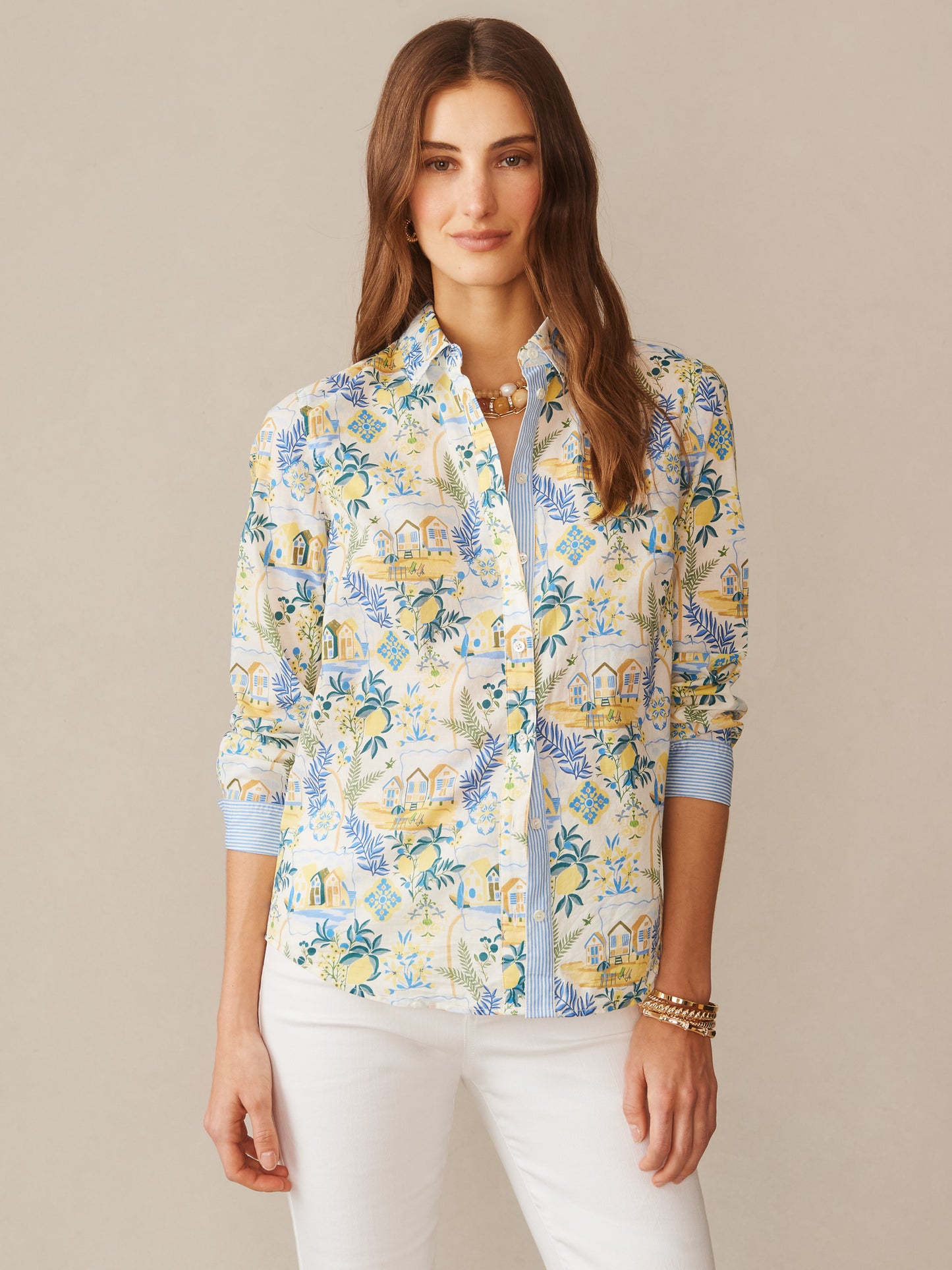 Woman wearing J.McLaughlin Lois Shirt in Mini Amalfi Coast Stripe with a vibrant coastal pattern in blue, yellow, and off-white tones, showcasing effortlessly stylish design and enduring appeal. A destination for defining style. Life, Well-Lived.