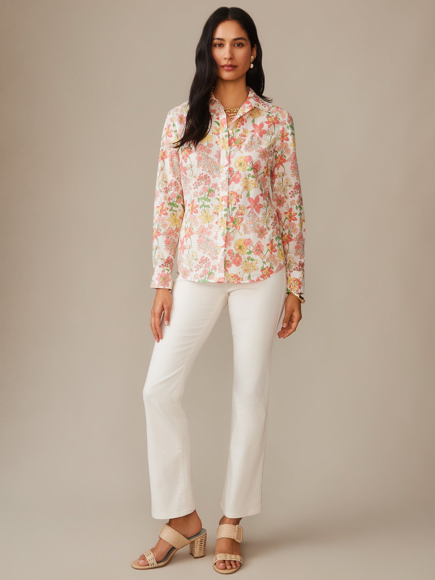 Woman wearing a J.McLaughlin Lois Shirt in Floral Villa with a delicate floral pattern in soft colors, paired with white pants and beige sandals, showcasing effortlessly stylish, enduring designs and innovative fabrics. A destination for defining style. Life, Well-Lived.