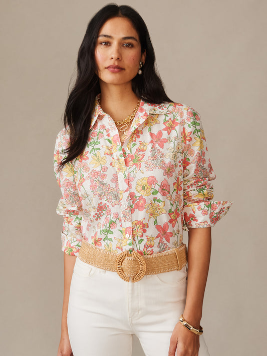 Woman wearing a J. McLaughlin Lois Shirt in Floral Villa with soft floral patterns, paired with a woven belt and white pants, showcasing effortlessly stylish, enduring designs.