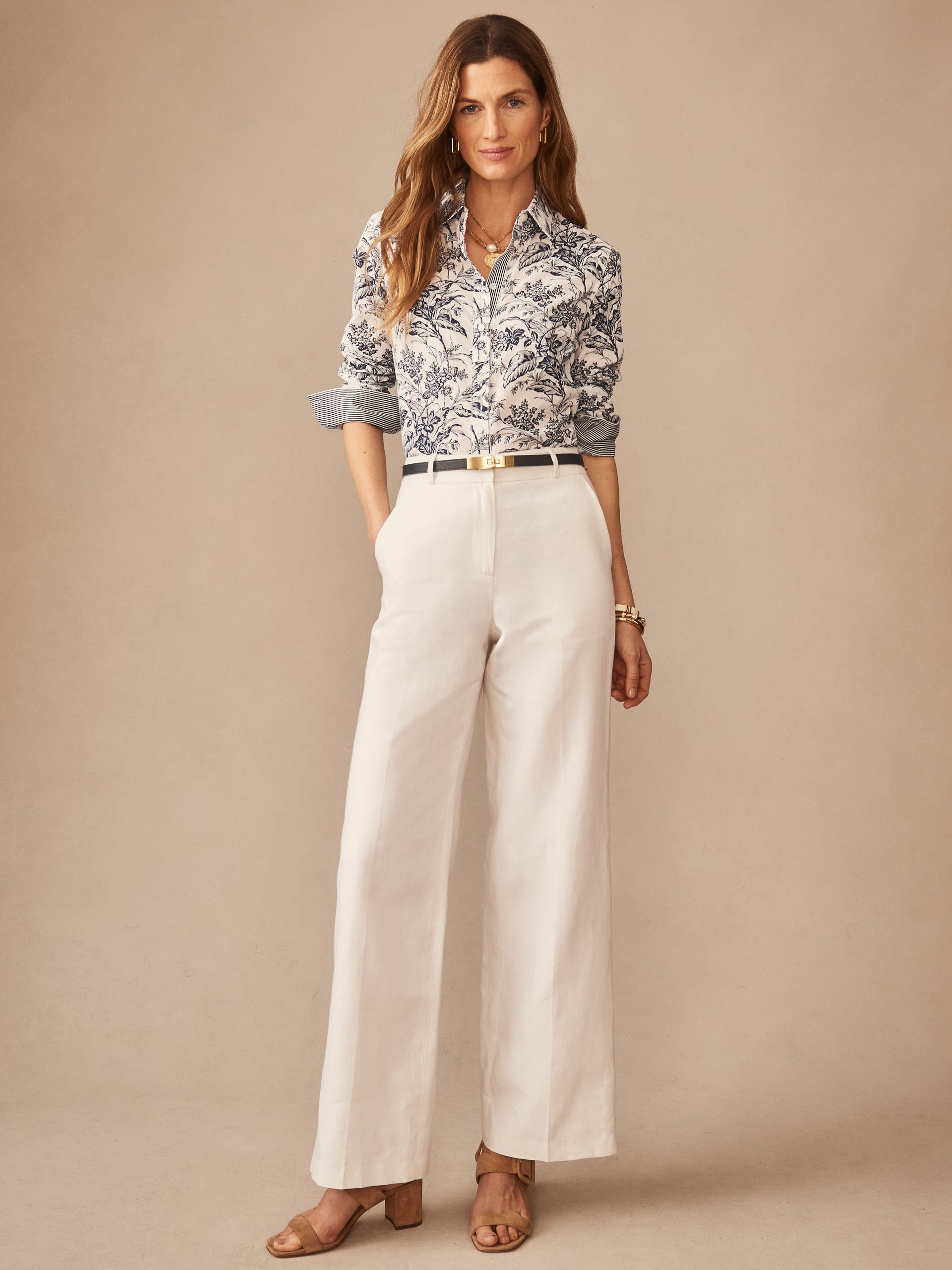 Woman wearing a Lois Shirt in Giardino Toile Stripe by J.McLaughlin with a classic botanical pattern, paired with white wide-leg pants and sandals, showcasing effortlessly stylish, enduring designs and innovative fabrics for a legacy of timeless fashion. A destination for defining style. Life, Well-Lived.