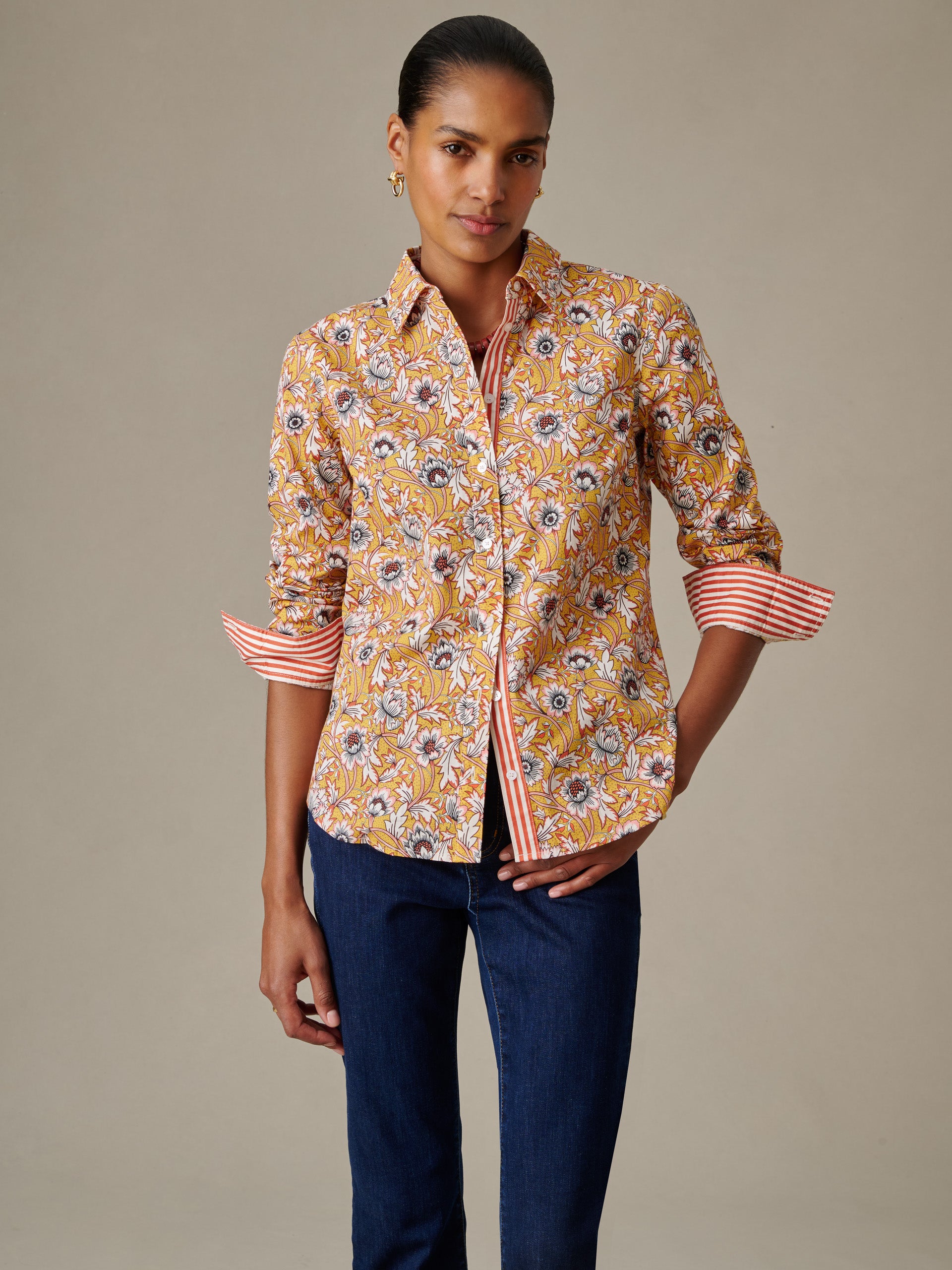 Woman wearing the Lois Shirt in Belle Epoque Bloom Stripe by J.McLaughlin featuring a floral pattern with rolled sleeves showing contrasting stripes, paired with dark jeans.