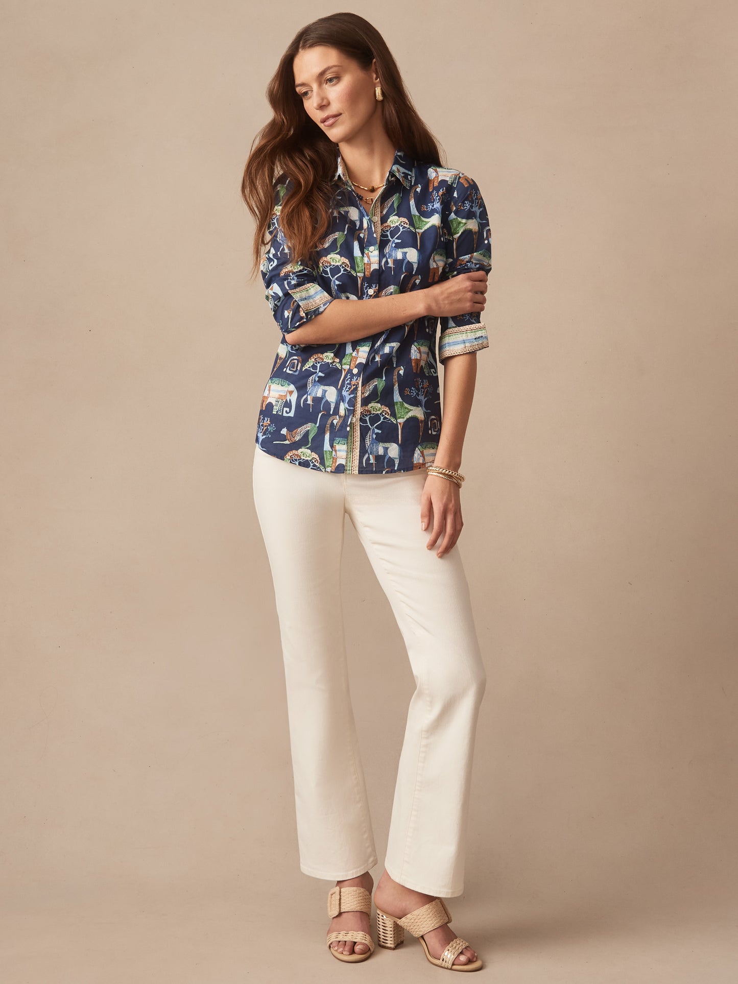 Woman wearing the Lois Shirt in The Wild Stripe by J.McLaughlin, styled with white pants and beige heeled sandals, showcasing effortlessly stylish, enduring designs and innovative fabrics.