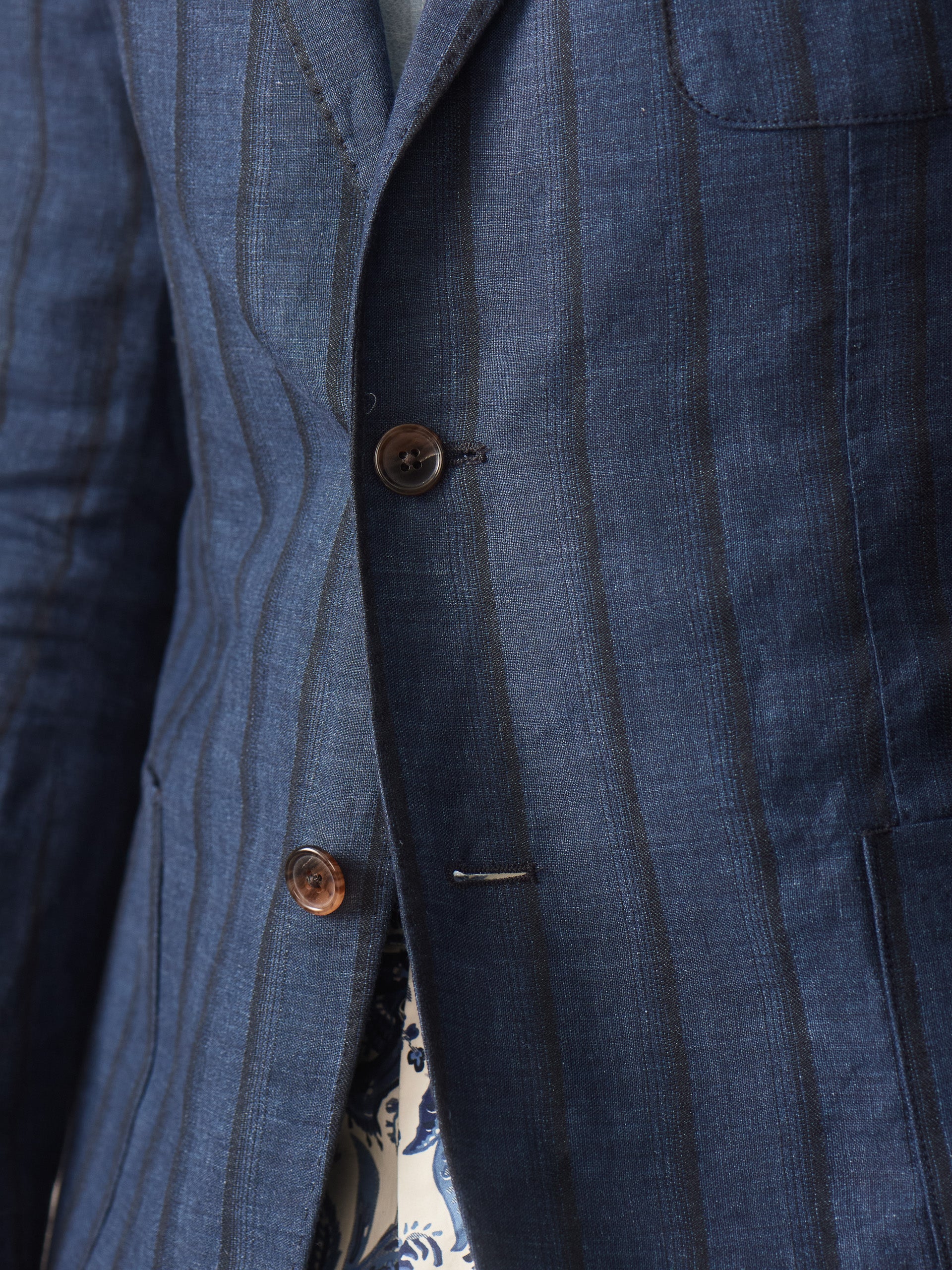 Close-up of a navy striped sport coat made from linen and silk, highlighting the fine craftsmanship of J.McLaughlin’s Brera Linen Silk Sport Coat in Stripe, showcasing effortlessly stylish, enduring designs with innovative fabrics.
