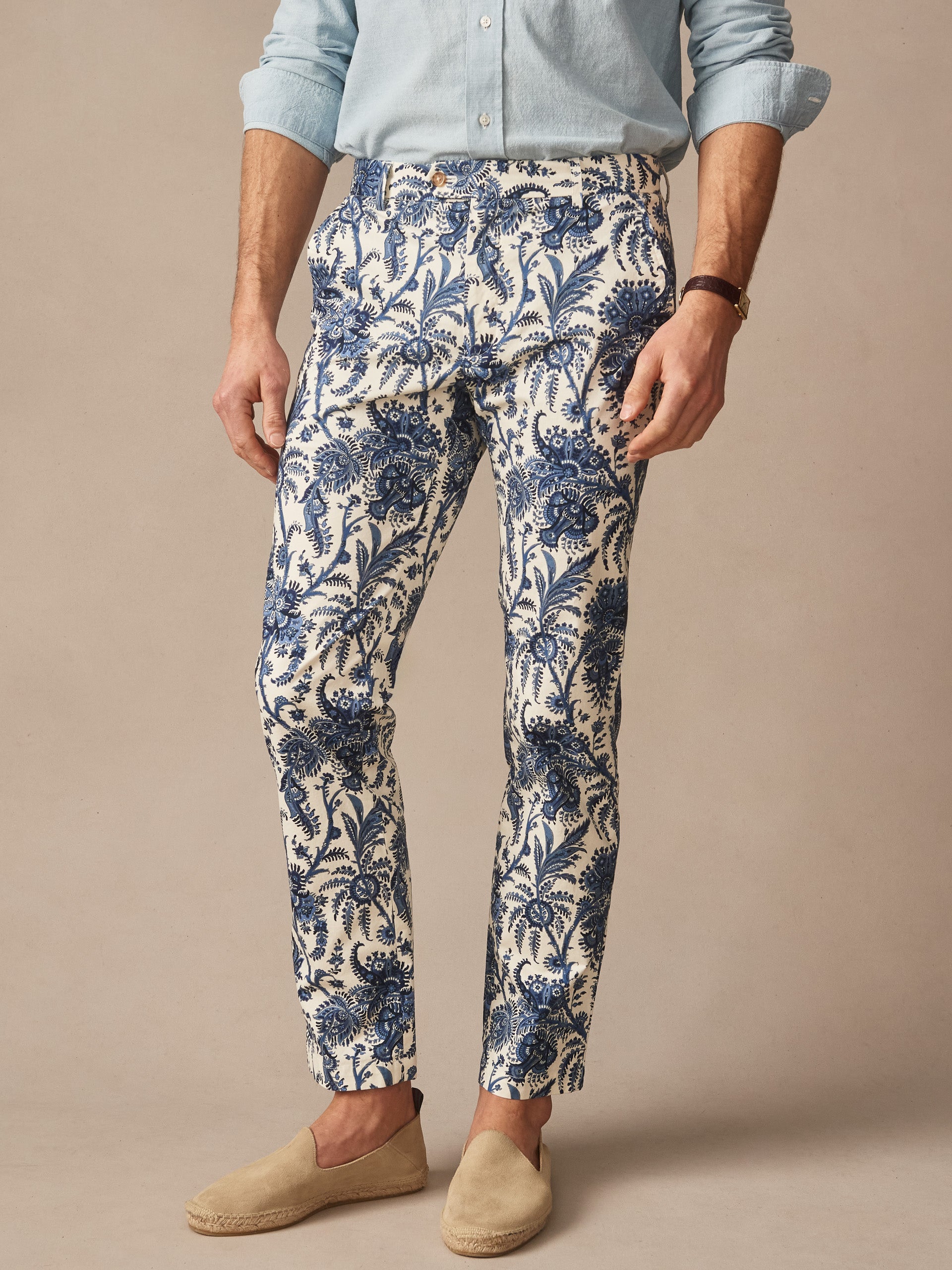 Man wearing Madison Fancy Pants in Heirloom Paisley by J.McLaughlin, featuring effortlessly stylish blue and cream patterned pants paired with casual slip-on shoes, showcasing enduring designs and innovative fabrics for a timeless look. A destination for defining style. Life, Well-Lived.