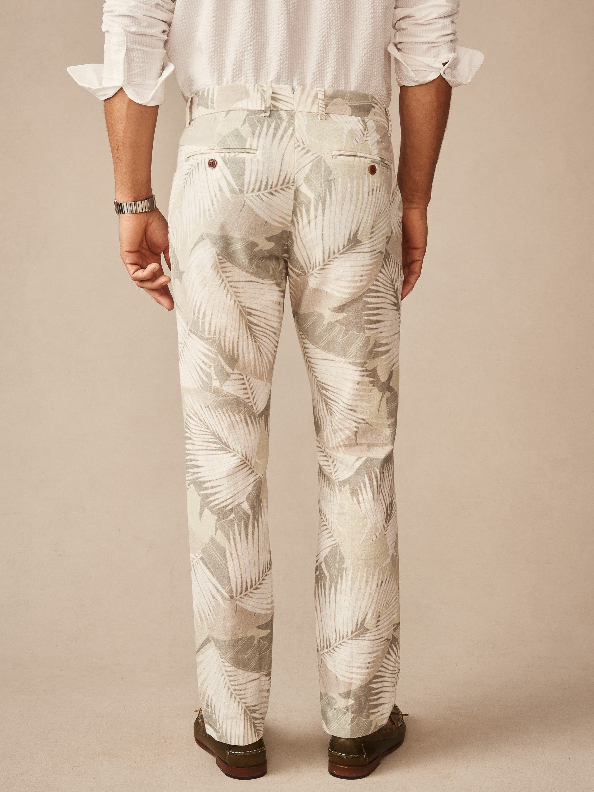 Back view of a man wearing Madison Fancy Pants in Vibrant Palms by J.McLaughlin, featuring a subtle palm leaf pattern in tan and brown, showcasing effortlessly stylish, enduring designs with innovative fabrics for a life well-lived.