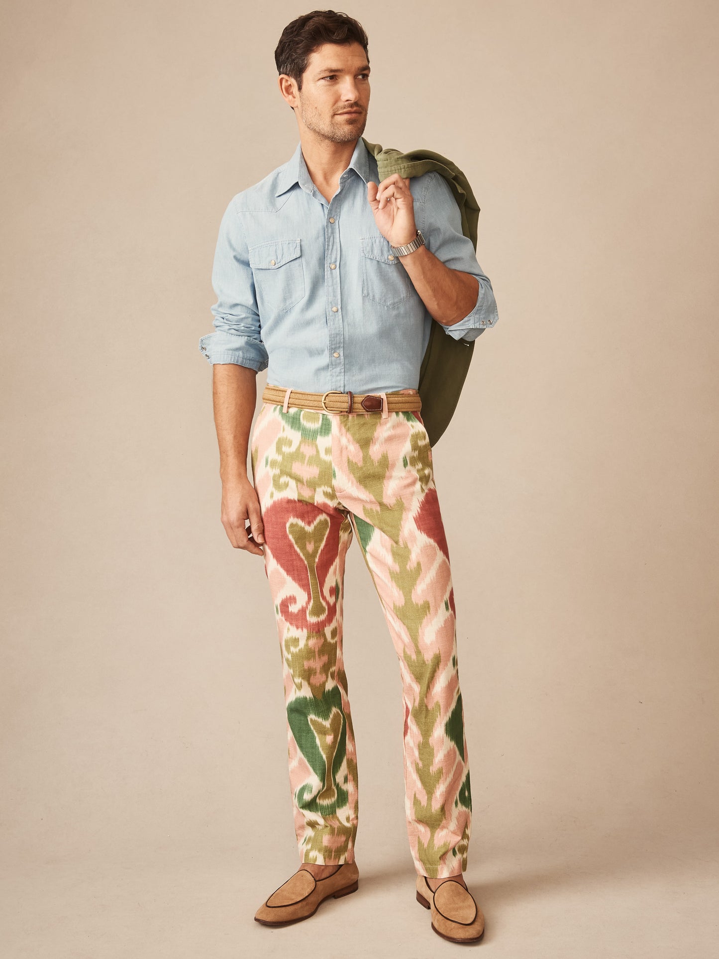 A stylish man wearing J. McLaughlin Madison Fancy Pants in Ikat with a light blue shirt and tan loafers, showcasing effortlessly stylish, enduring designs and innovative fabrics.