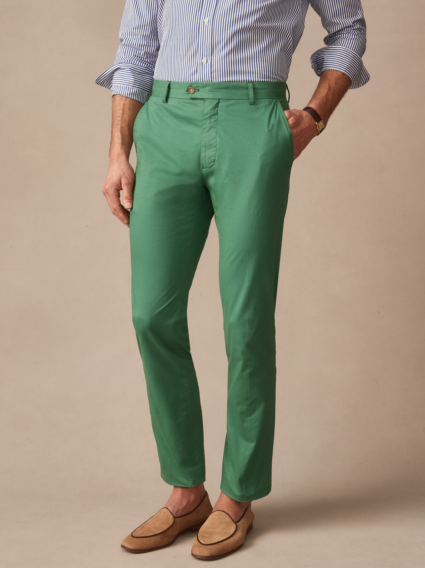 Man wearing J.McLaughlin Madison Pants in moss green paired with a striped shirt and loafers, showcasing effortlessly stylish pants with enduring designs and innovative fabrics.