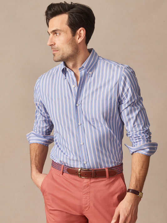 Man wearing a Belvedere Cotton Shirt in Multi Stripe with blue and white vertical stripes paired with red pants and a brown belt, showcasing J.McLaughlin’s effortlessly stylish, enduring designs and innovative fabrics. A destination for defining style. Life, Well-Lived.