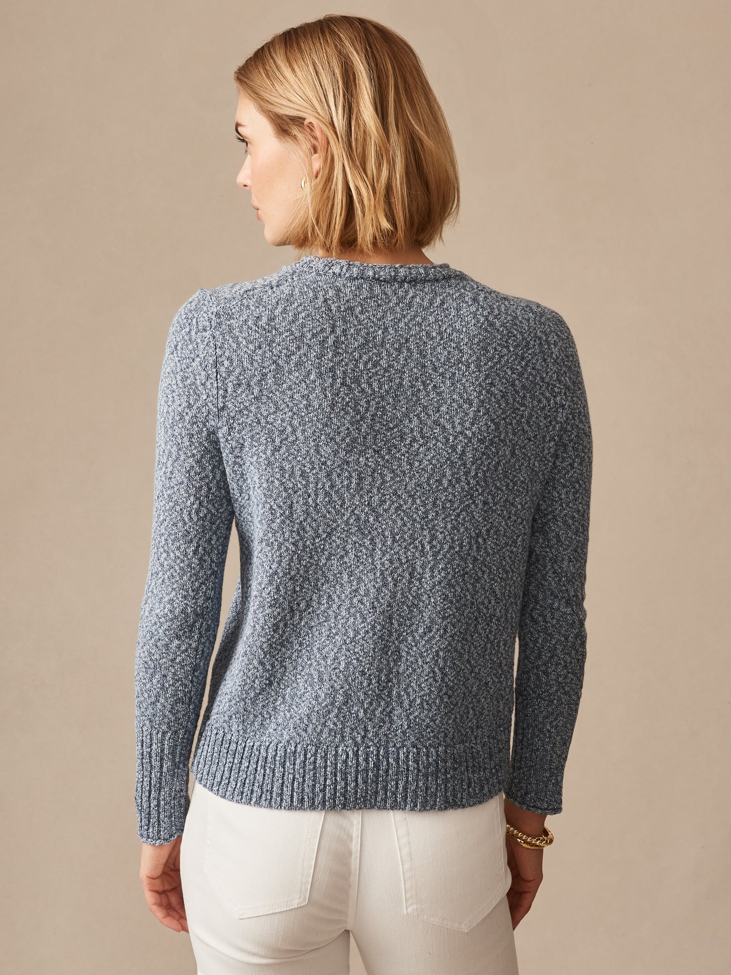 Back view of a woman wearing a light blue Mae Sweater by J.McLaughlin, showcasing effortlessly stylish knitwear that blends enduring designs with innovative fabrics for timeless fashion.