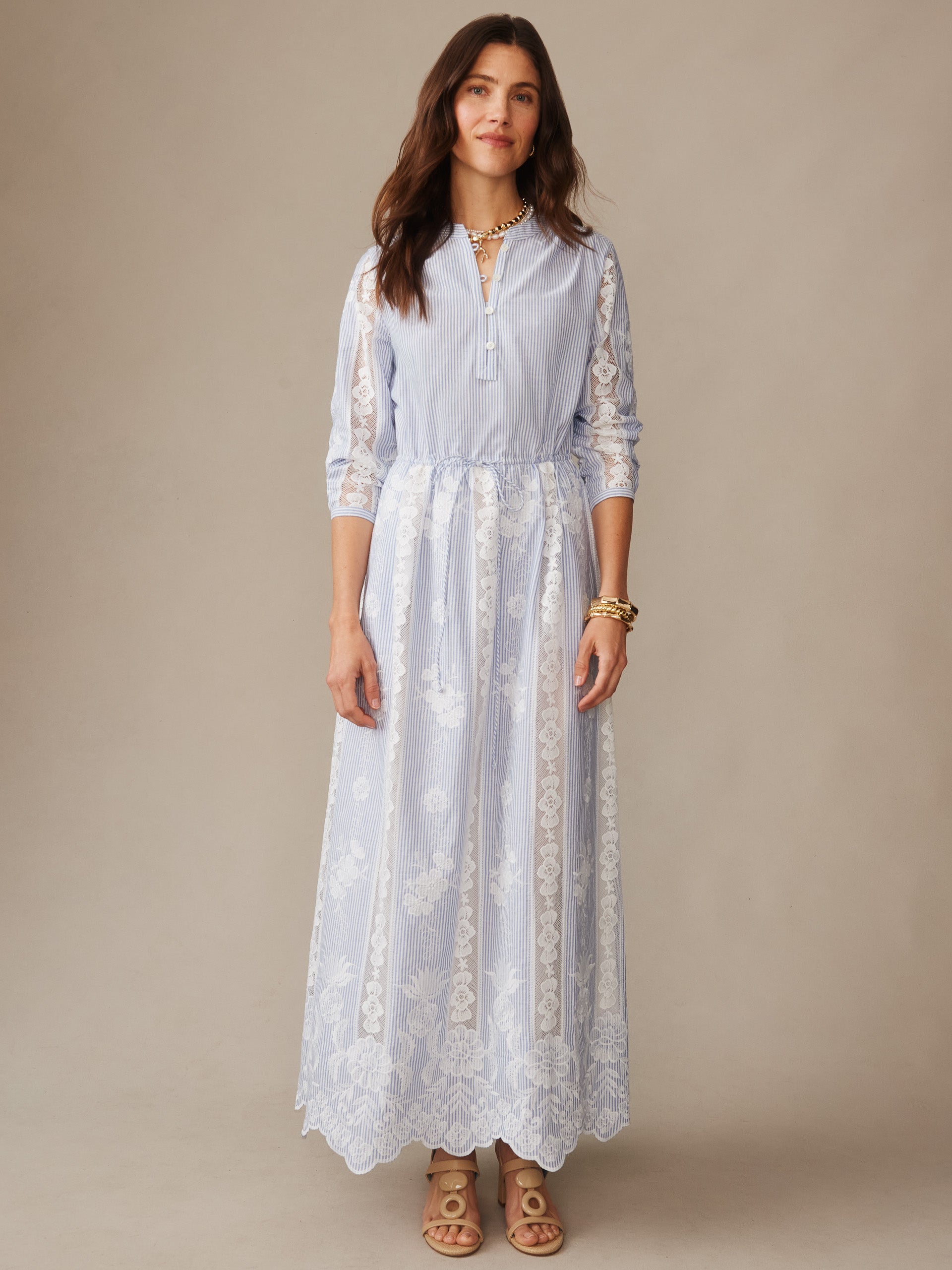 Woman wearing a Margaret Dress in Stripe by J.McLaughlin, featuring delicate lace details over light blue stripes, embodying effortlessly stylish and enduring designs for a destination defining style. Life, Well-Lived.