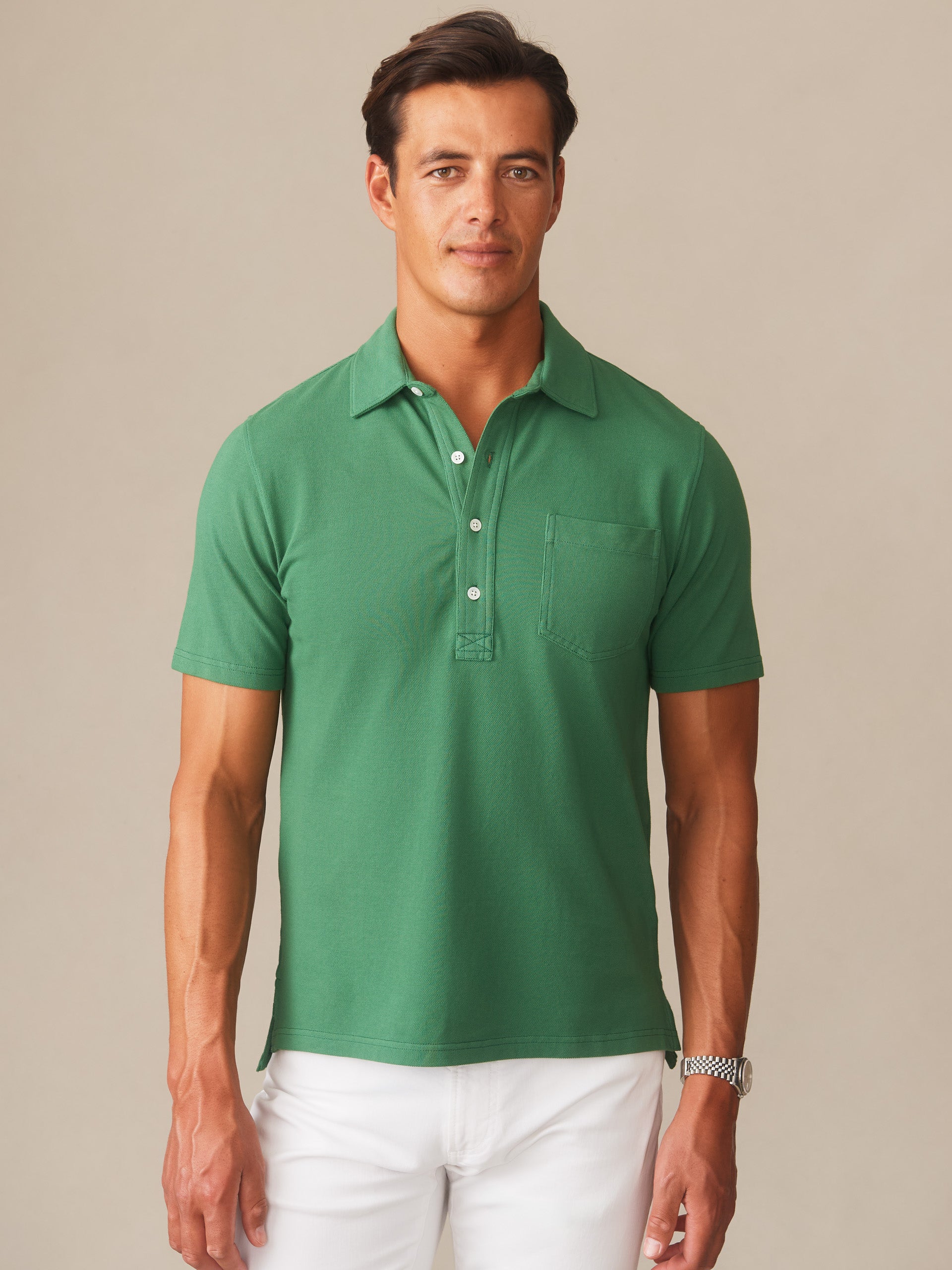 Man wearing a green Mantle Pique Polo by J.McLaughlin, showcasing effortlessly stylish, enduring designs with innovative fabrics, embodying a legacy of timeless fashion. A destination for defining style. Life, Well-Lived.