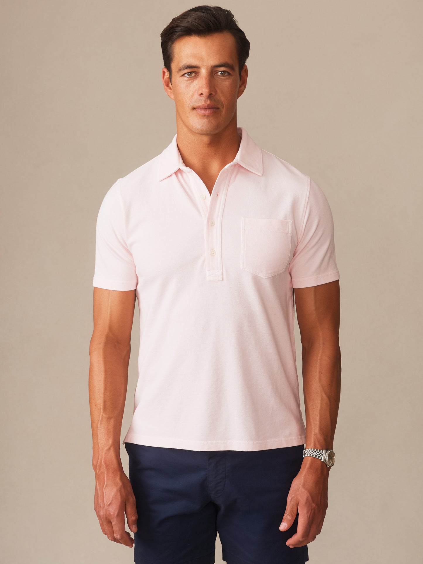 A man modeling the Mantle Pique Polo by J.McLaughlin in a soft quartz color, showcasing effortlessly stylish, enduring designs with innovative fabrics and a legacy of timeless fashion. A destination for defining style. Life, Well-Lived.