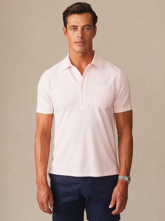 A man modeling the Mantle Pique Polo by J.McLaughlin in a soft quartz color, showcasing effortlessly stylish, enduring designs with innovative fabrics and a legacy of timeless fashion. A destination for defining style. Life, Well-Lived.