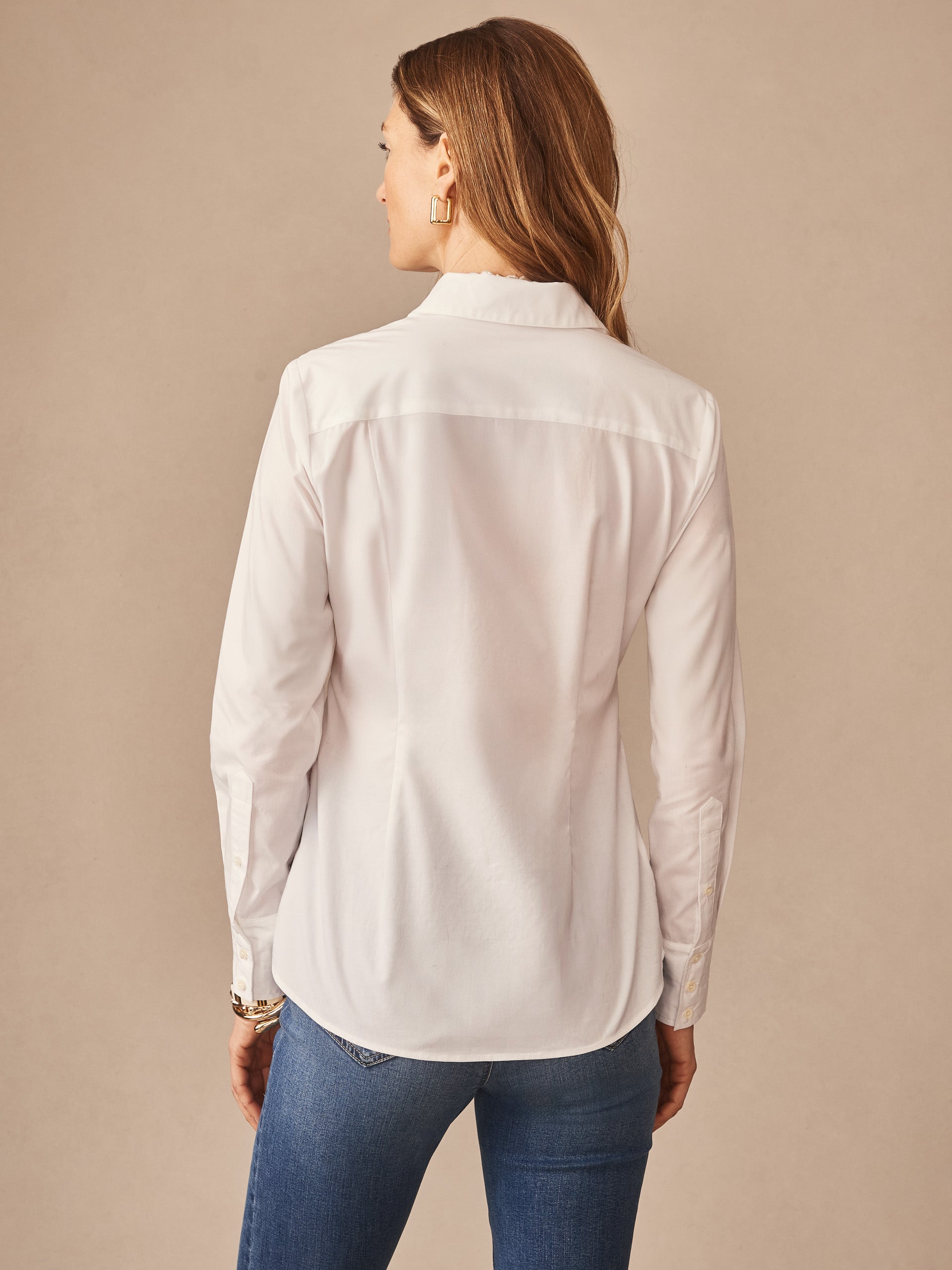 A woman wearing the Margaux Shirt by J.McLaughlin, showcasing effortlessly stylish, enduring designs with innovative fabrics in a timeless white shirt, perfect for a life well-lived.