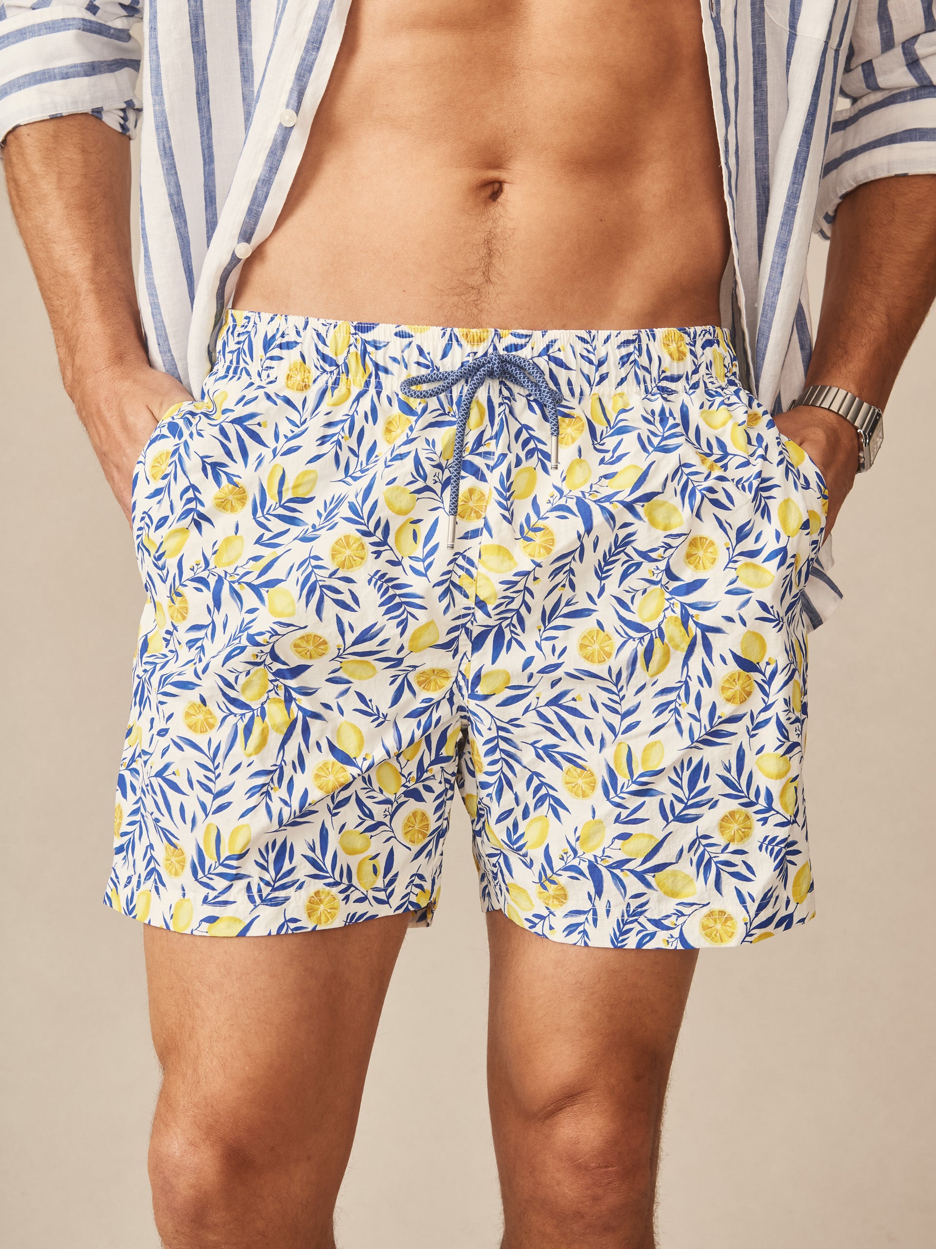Man wearing Marina Swim Trunks in Capri Spritz by J.McLaughlin, featuring a lively lemon and leaf pattern with an effortlessly stylish, enduring design for a life well-lived.