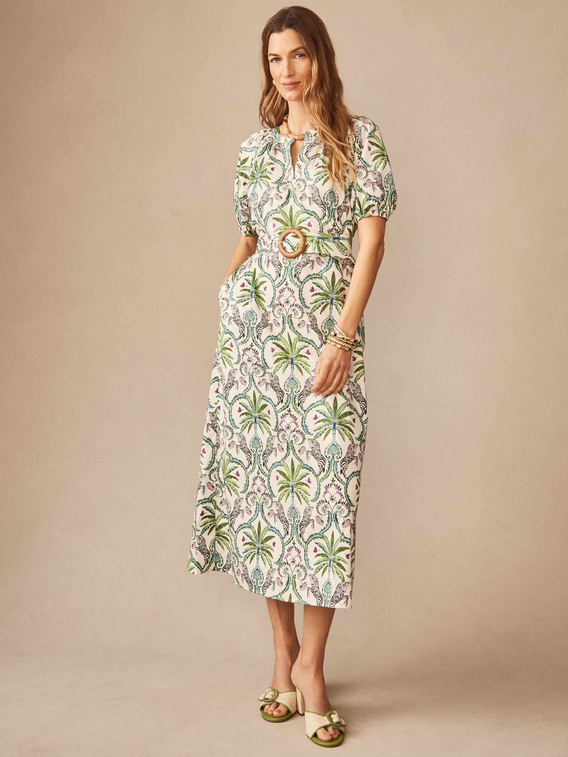 Woman wearing Marley Dress in Zebra Isle by J.McLaughlin, featuring an elegant palm leaf pattern with a belted waist, reflecting effortlessly stylish, enduring designs and innovative fabrics.