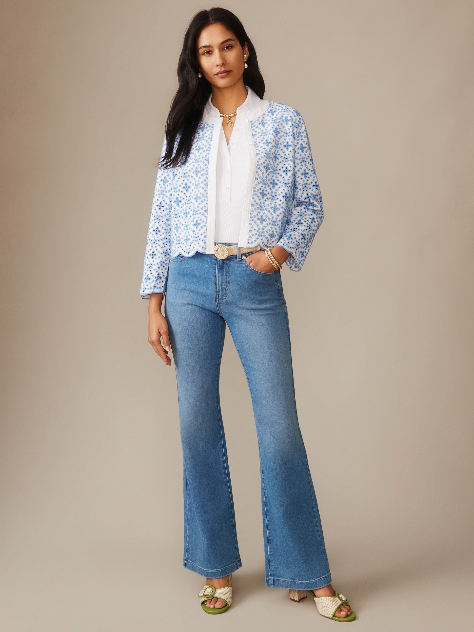Woman wearing a Martha Linen Blend Eyelet Jacket by J.McLaughlin in light blue and white with floral embroidery, paired with a white blouse and blue jeans, showcasing effortlessly stylish, enduring designs and innovative fabrics. A destination for defining style. Life, Well-Lived.