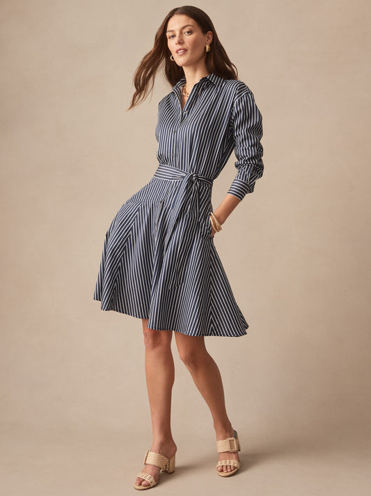 Woman wearing a navy and white striped Mary Dress in Stripe by J.McLaughlin, showcasing effortlessly stylish, enduring designs crafted from innovative fabrics, embodying a legacy of timeless fashion. A destination for defining style. Life, Well-Lived.