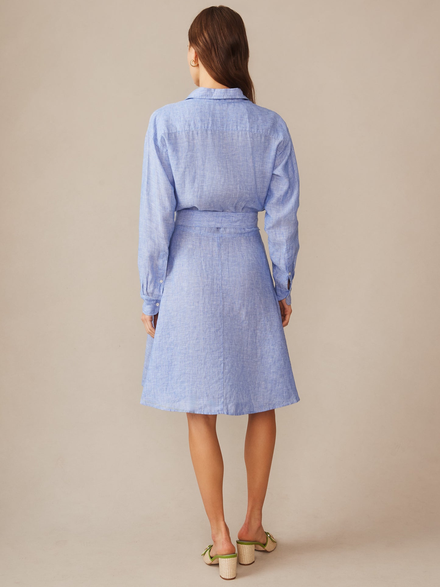 Woman wearing a light blue Mary Linen Dress in Stripe by J.McLaughlin, showcasing effortlessly stylish, enduring designs with innovative fabrics for a legacy of timeless fashion.