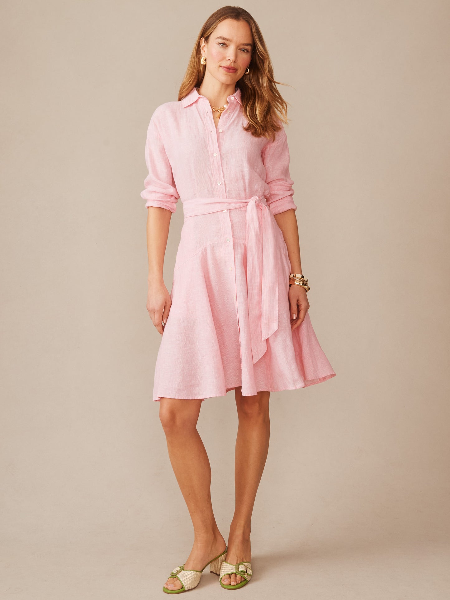 Woman wearing a pink Mary Linen Dress in Stripe by J.McLaughlin, featuring a belted waist and relaxed fit, embodying effortlessly stylish, enduring designs with a legacy of timeless fashion.