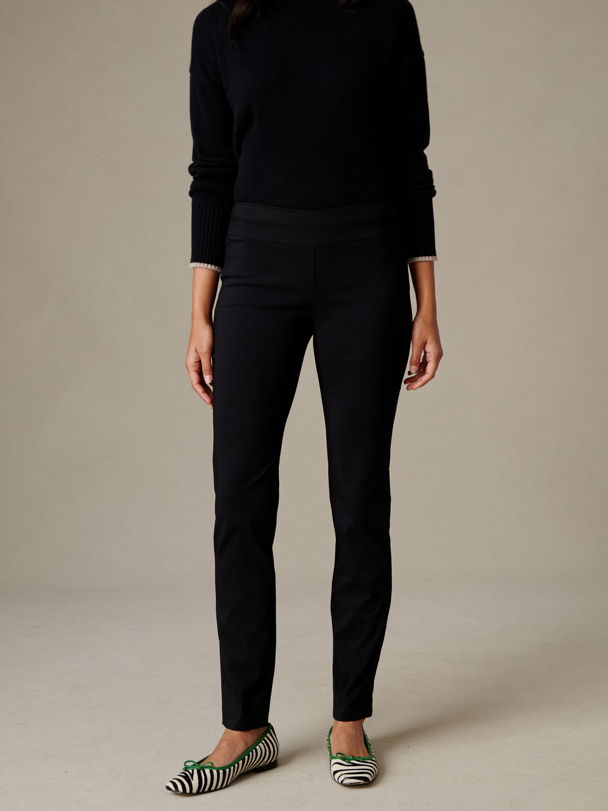 Model wearing black Masie Pants by J.McLaughlin with a sleek tailored fit and striped flats against a neutral studio backdrop