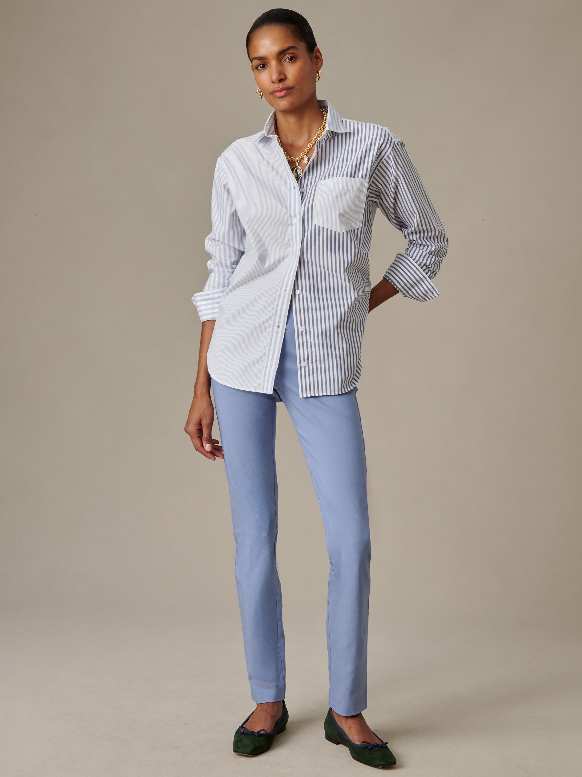Woman wearing J.McLaughlin Masie Pants in light blue paired with a stylish striped and solid button-down shirt, showcasing effortlessly stylish and enduring designs.