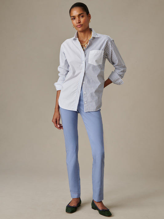 Woman wearing J.McLaughlin Masie Pants in light blue paired with a stylish striped and solid button-down shirt, showcasing effortlessly stylish and enduring designs.