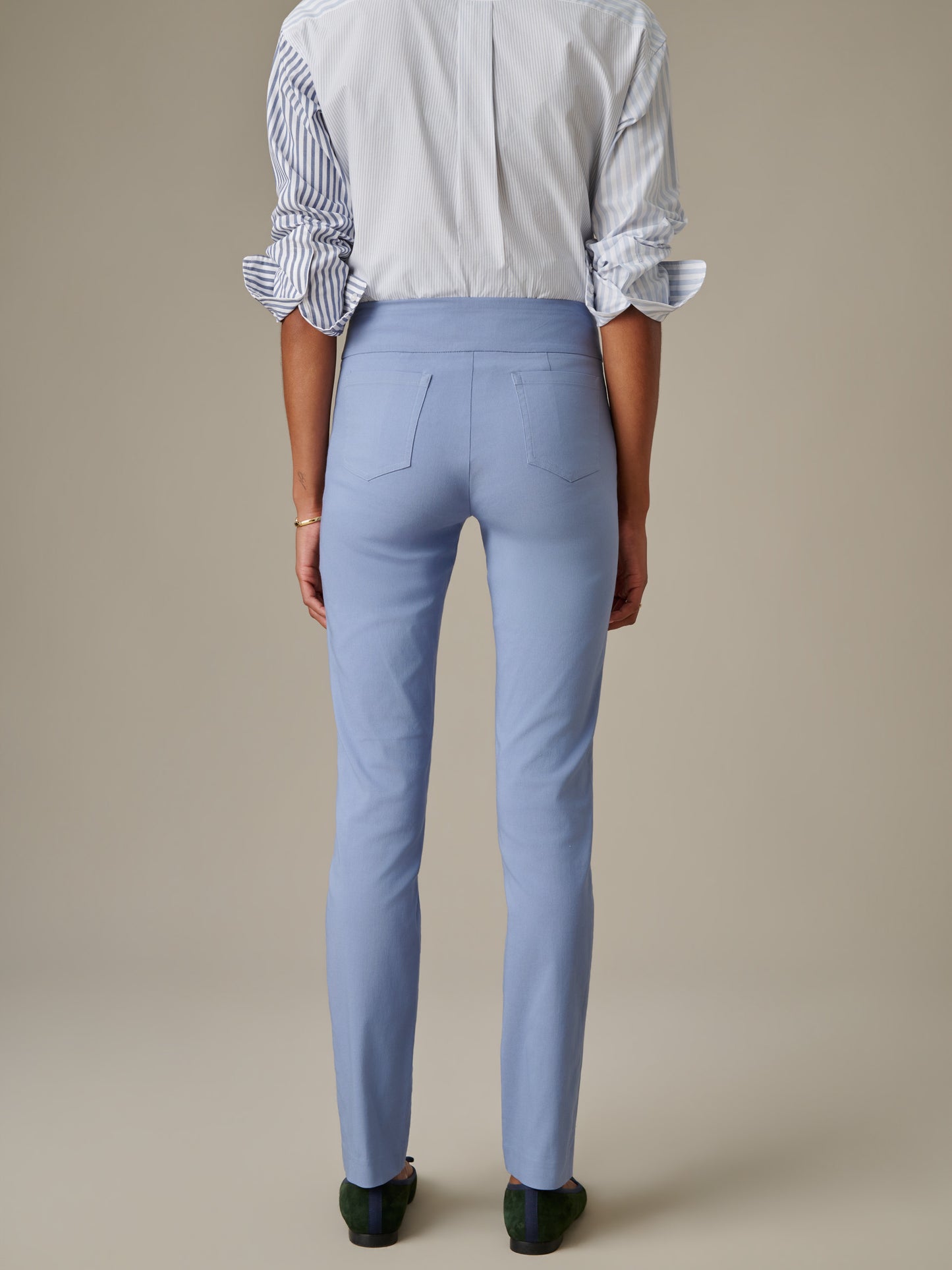Back view of a person wearing light blue Masie Pants by J.McLaughlin paired with a white and blue striped shirt, showcasing a tailored fit and classic style for enduring fashion.
