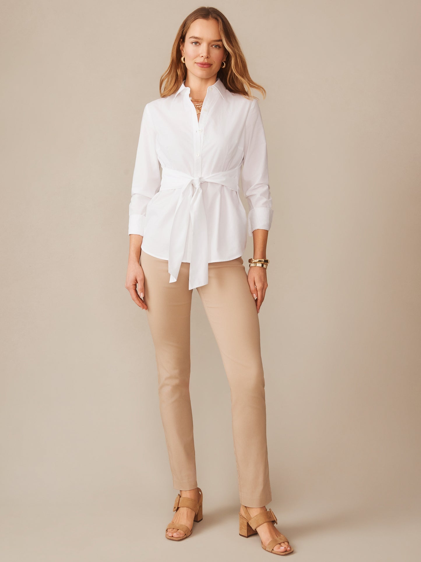 Woman wearing Masie Pants in a warm neutral tone paired with a white blouse, showcasing J.McLaughlin’s effortlessly stylish, enduring designs and innovative fabrics.