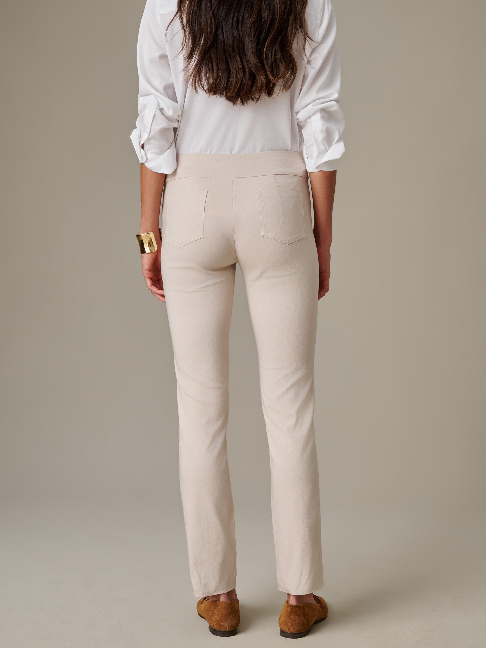 Woman wearing cream-colored Masie Pants by J.McLaughlin paired with a white blouse, showcasing effortlessly stylish and enduring design for timeless fashion.