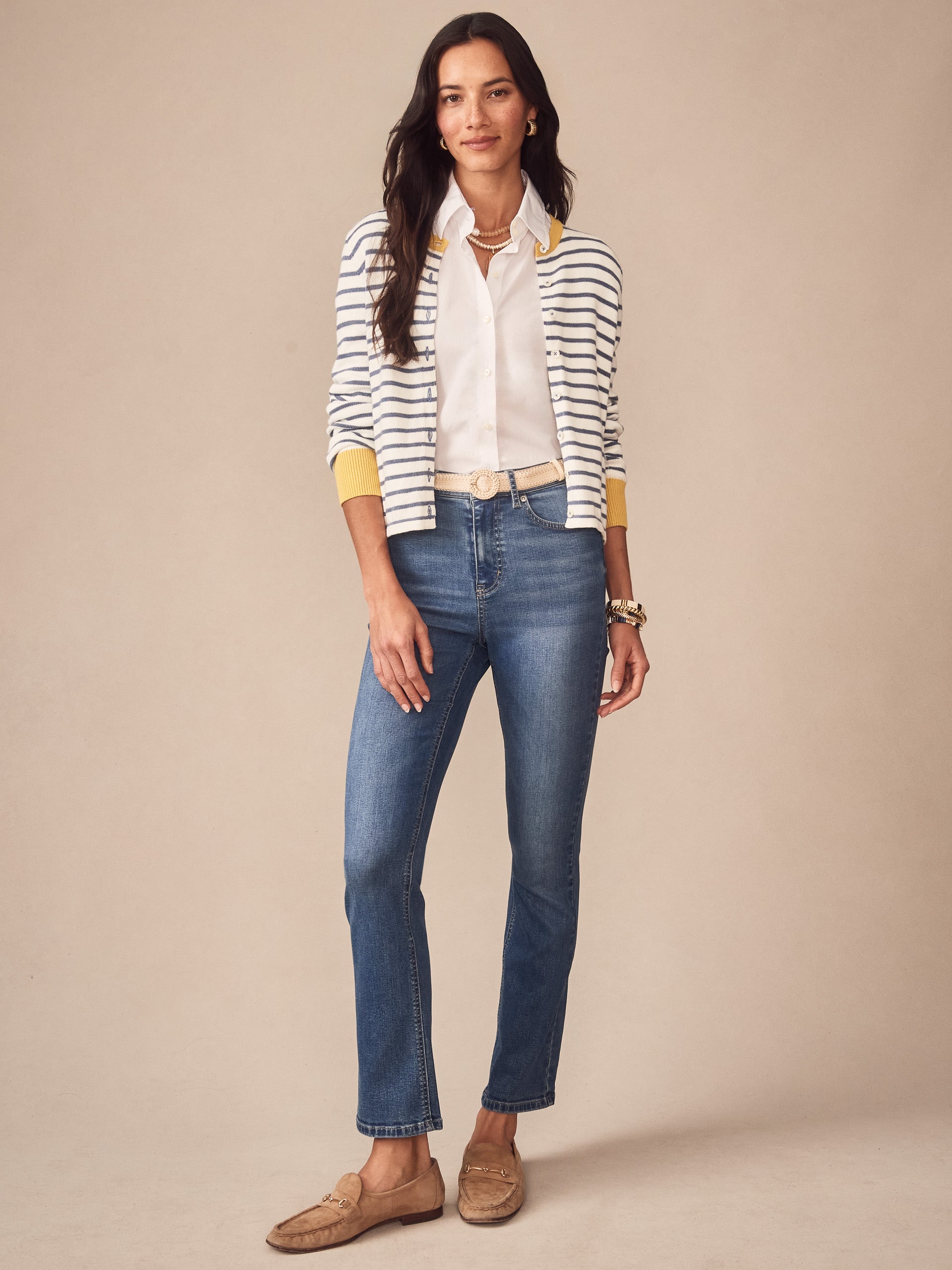 Woman wearing the Matilda Cardigan in Stripe by J.McLaughlin paired with a white blouse, blue jeans, and tan loafers, showcasing effortlessly stylish, enduring designs and innovative fabrics.
