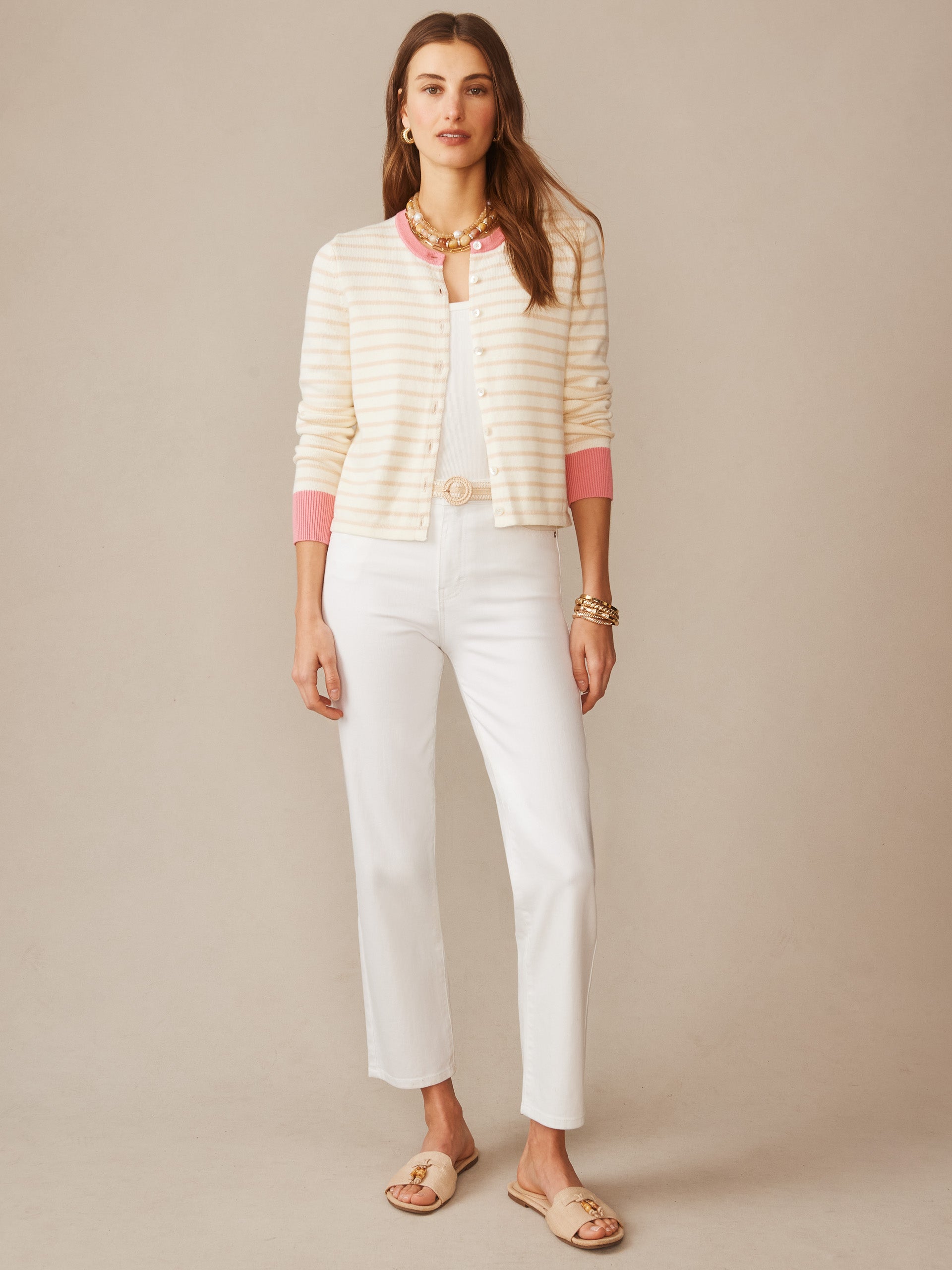 A woman wearing the Matilda Cardigan in Stripe by J.McLaughlin, styled with white pants and sandals, showcasing effortlessly stylish and enduring designs made from innovative fabrics, embodying a legacy of timeless fashion in a destination for defining style. Life, Well-Lived.