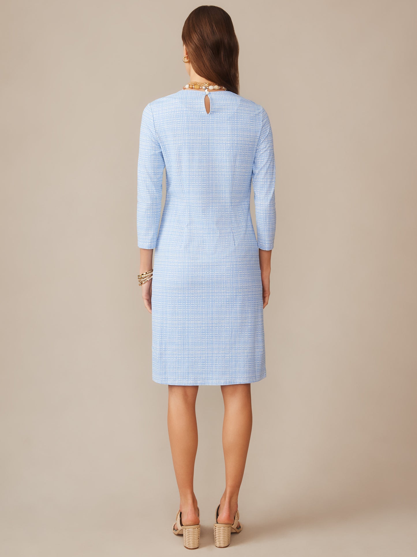 Woman wearing a light blue "Catalyst Dress in Pocket Square" by J.McLaughlin, featuring a classic fit with three-quarter sleeves and subtle check pattern, shown from the back.