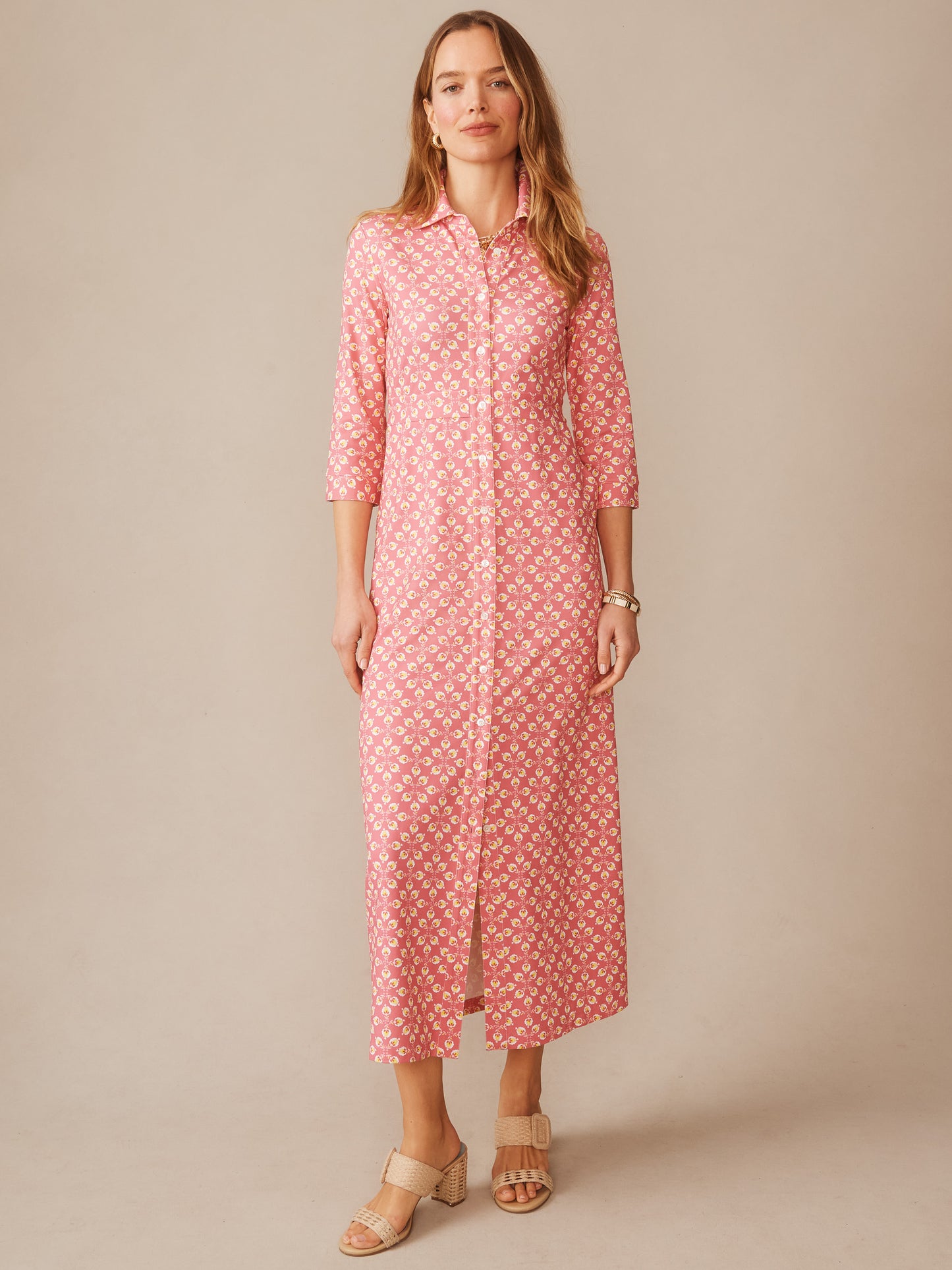 Woman wearing a Kailyn Maxi Dress in Mythic Floral Geo by J.McLaughlin, featuring a pink floral pattern and button-down front, embodying effortlessly stylish, enduring designs for a life well-lived.