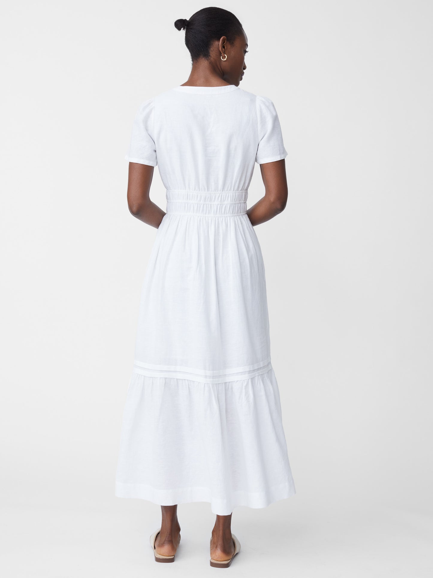 Model wearing J.McLaughlin Mei dress in white made with linen.
