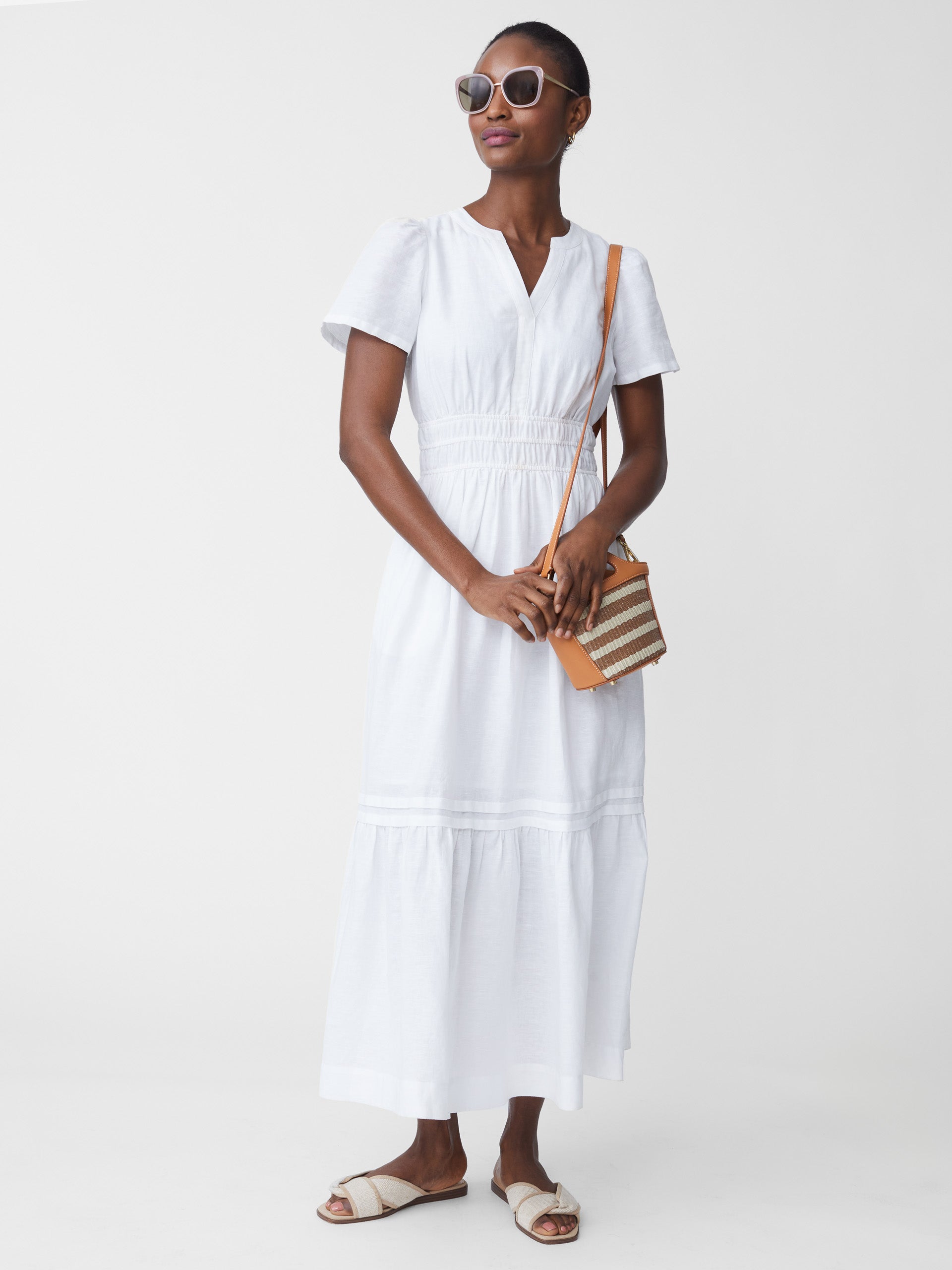 Model wearing J.McLaughlin Mei dress in white made with linen.