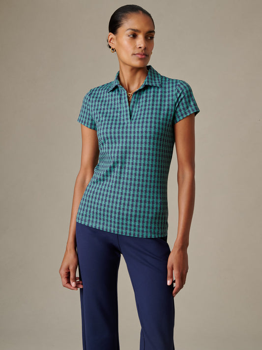 Woman wearing a Merlin Cap Sleeve Polo in Algiers Check by J.McLaughlin, styled with navy pants, showcasing effortlessly stylish and enduring designs for timeless fashion.