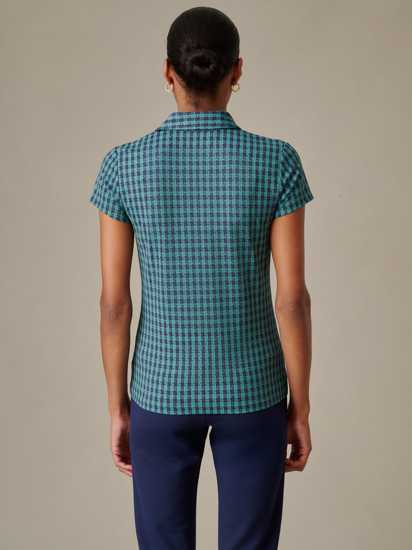 Back view of a woman wearing the Merlin Cap Sleeve Polo in Algiers Check by J.McLaughlin, showcasing a timeless pattern and classic fit that embodies enduring designs and impeccable craftsmanship.