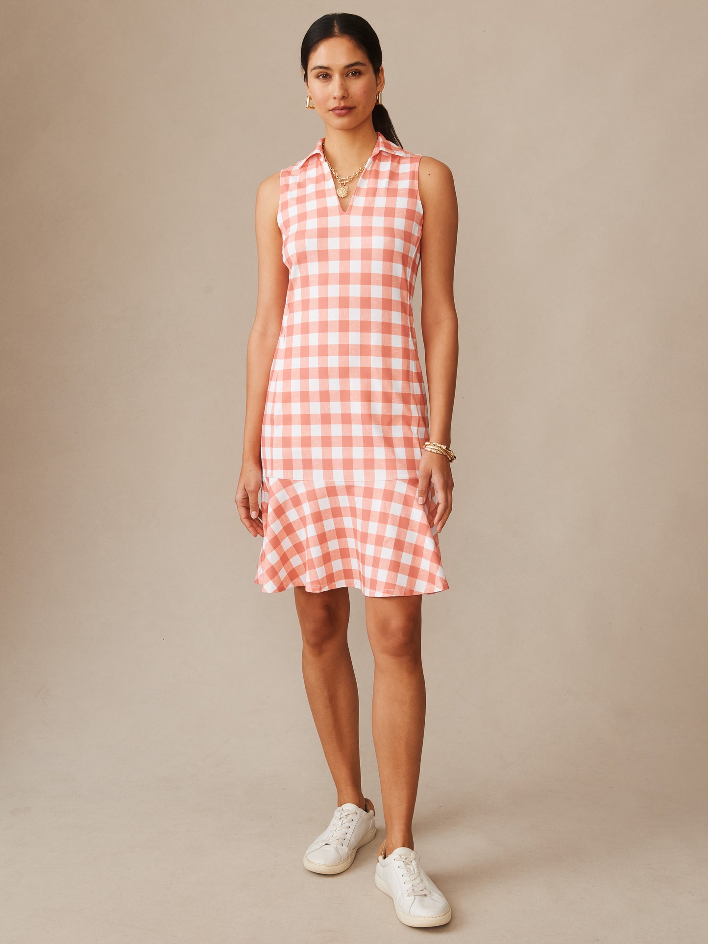 Woman wearing J.McLaughlin Merlin Dress in Textured Gingham, featuring coral and white check pattern with a sleeveless design and a flared hem, showcasing effortlessly stylish, enduring designs with a legacy of timeless fashion. A destination for defining style. Life, Well-Lived.