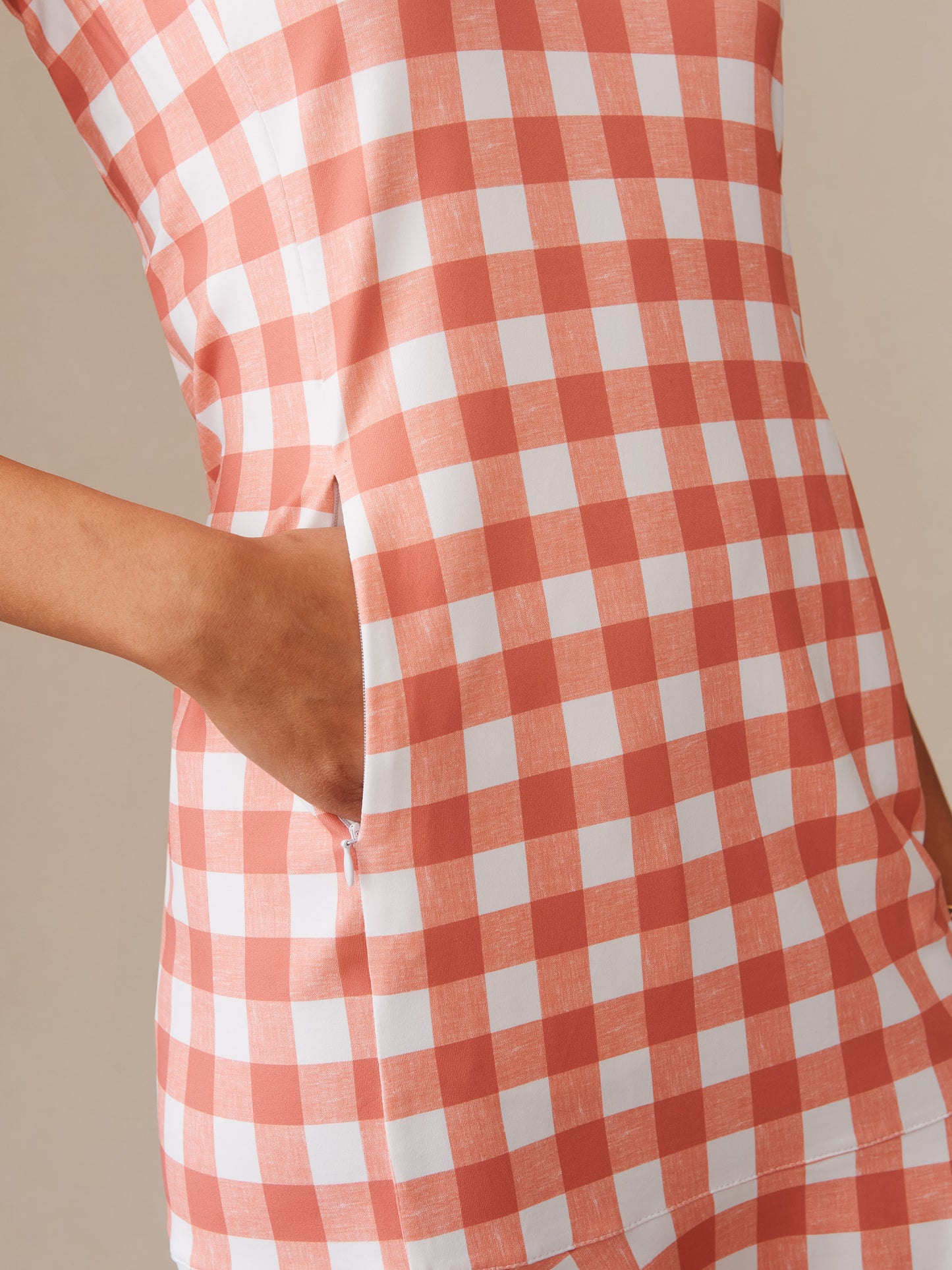 Close-up of a hand casually placed in the pocket of the Merlin Dress in Textured Gingham by J.McLaughlin, showcasing effortlessly stylish, enduring designs with innovative fabrics.