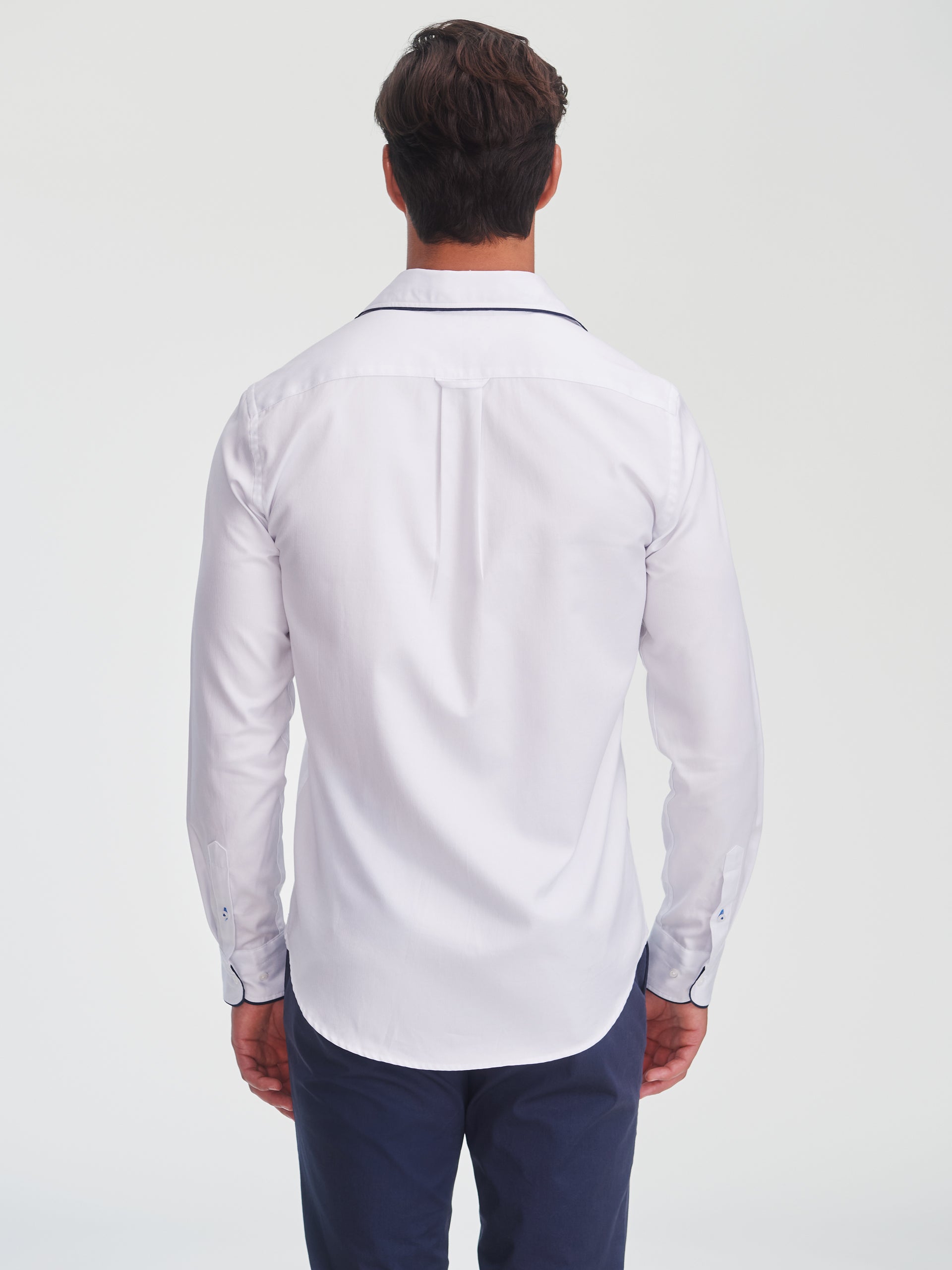 Man wearing a white Anderson Cotton Shirt by J.McLaughlin, showcasing an effortlessly stylish design with subtle detailing, embodying enduring designs and innovative fabrics.