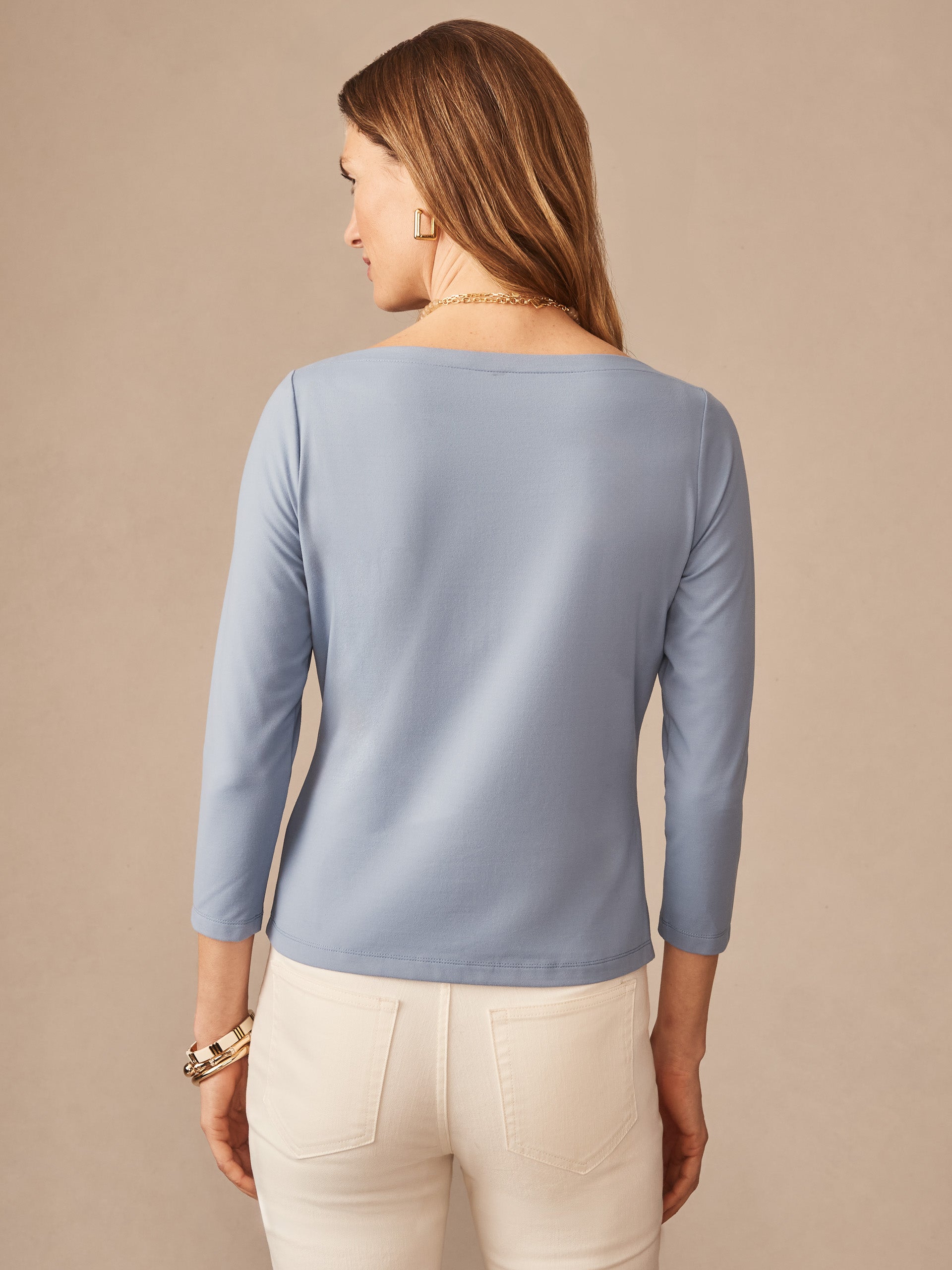 Woman wearing a frost blue Natasha Tee by J.McLaughlin with long sleeves and a classic fit, showcasing effortlessly stylish and enduring designs for a life well-lived.