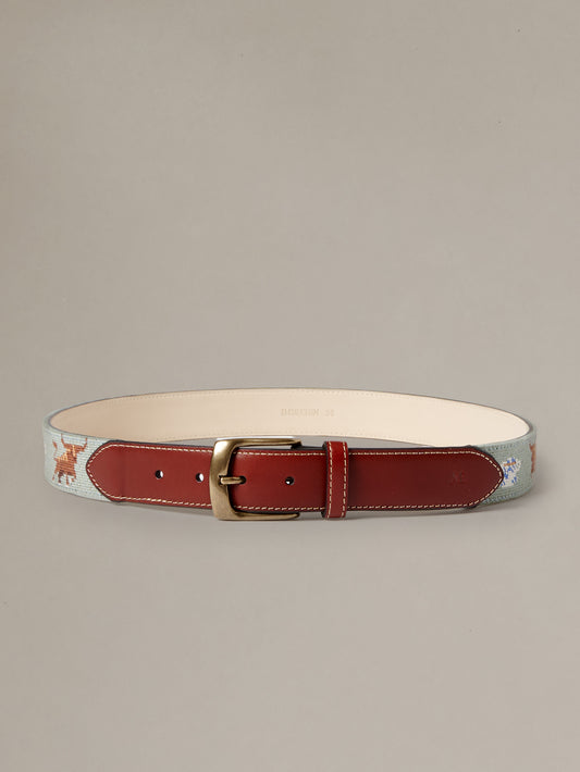 Needlepoint Belt in Bull in China Shop by J.McLaughlin with red leather detailing and an English brass buckle shown against a neutral background