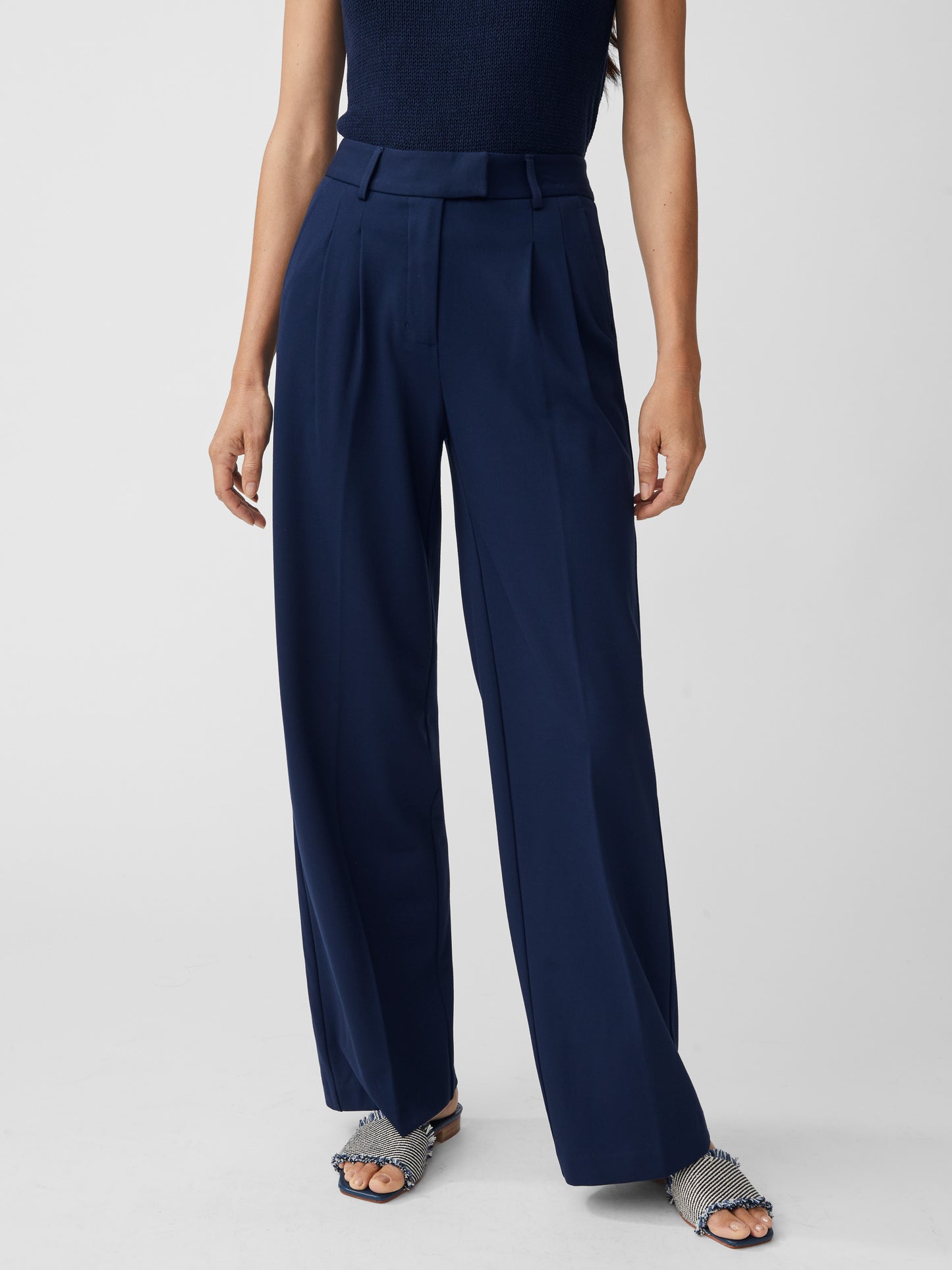 Model wearing J.McLaughlin Newman pants in winter navy made with polyester/viscose/elastane.