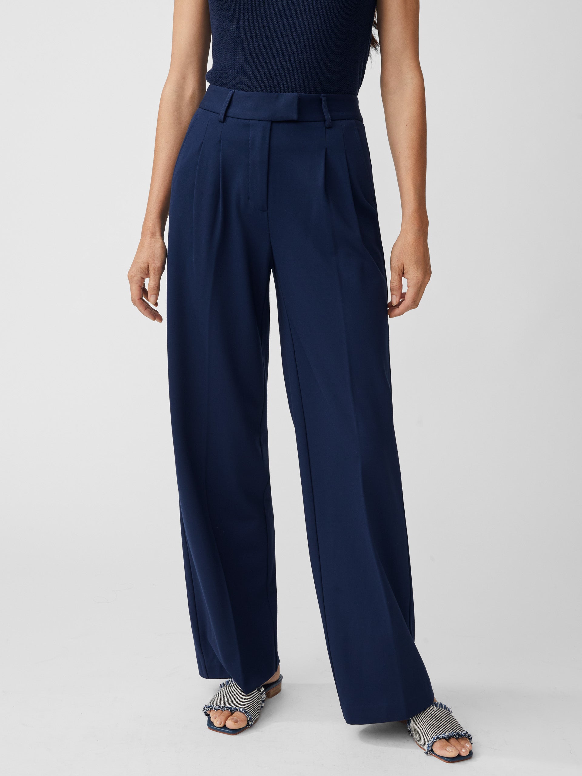 Model wearing J.McLaughlin Newman pants in winter navy made with polyester/viscose/elastane.